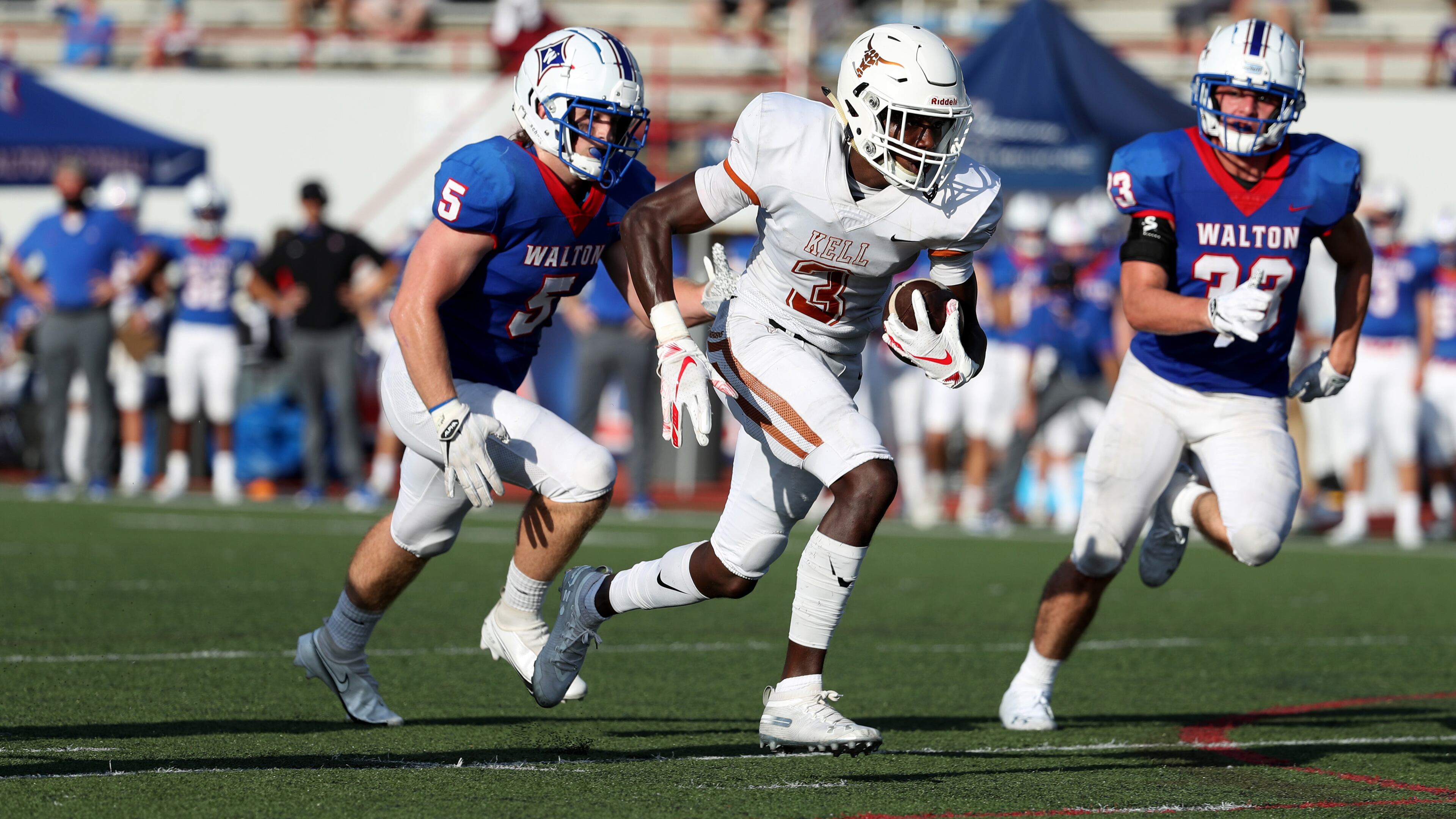 Kell wide receiver Jaylon Brown (3) runs after a catch for a touchdown against Walton defenders Preston Evans (5) and Eric Zeiher (33) in the first half at Walton high school Friday, September 4, 2020 in Marietta, Ga.. This is one of several football games during the 2020 Corky Kell Classic. (Jason Getz/Special to the AJC)