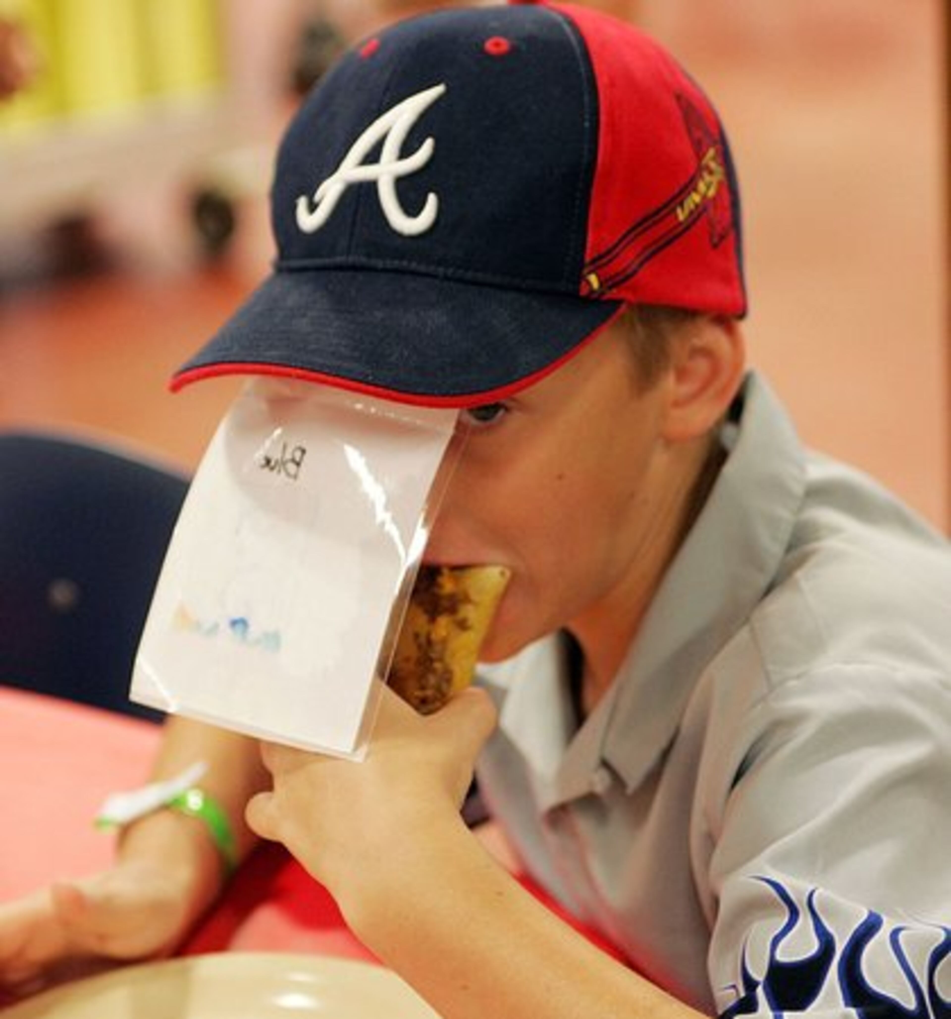 Jamie Diefenderfer covers his face with a table marker while clowning around with friends at mealtime.