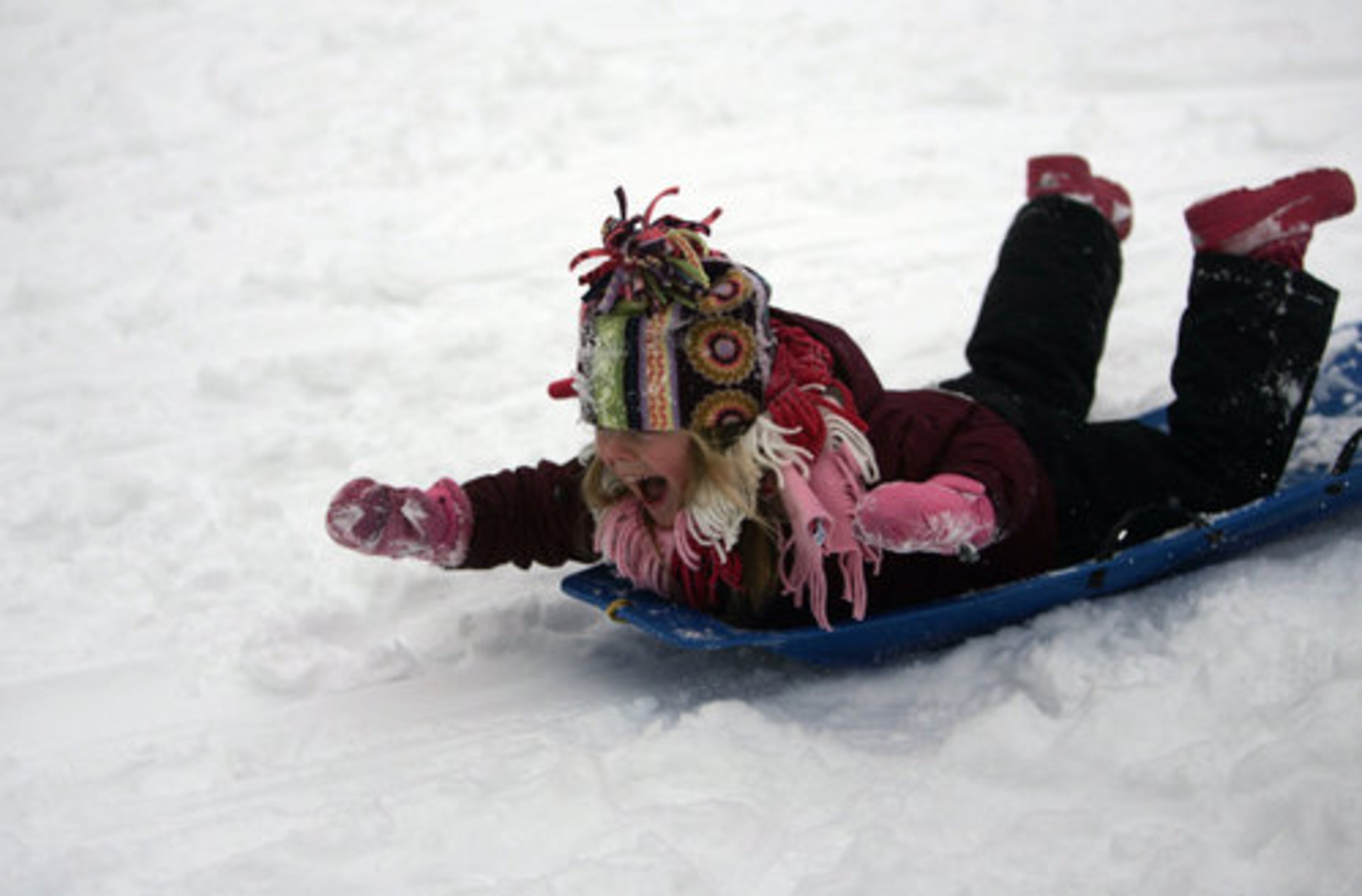 Alli Contat, 4, of Royal Oak, Michigan, sides down a hill at Pioneer Park in Royal Oak. Metro Detroiters dig out from the weather system that dropped 8 to 10 inches of snow across the region, closing hundreds of schools through the region.