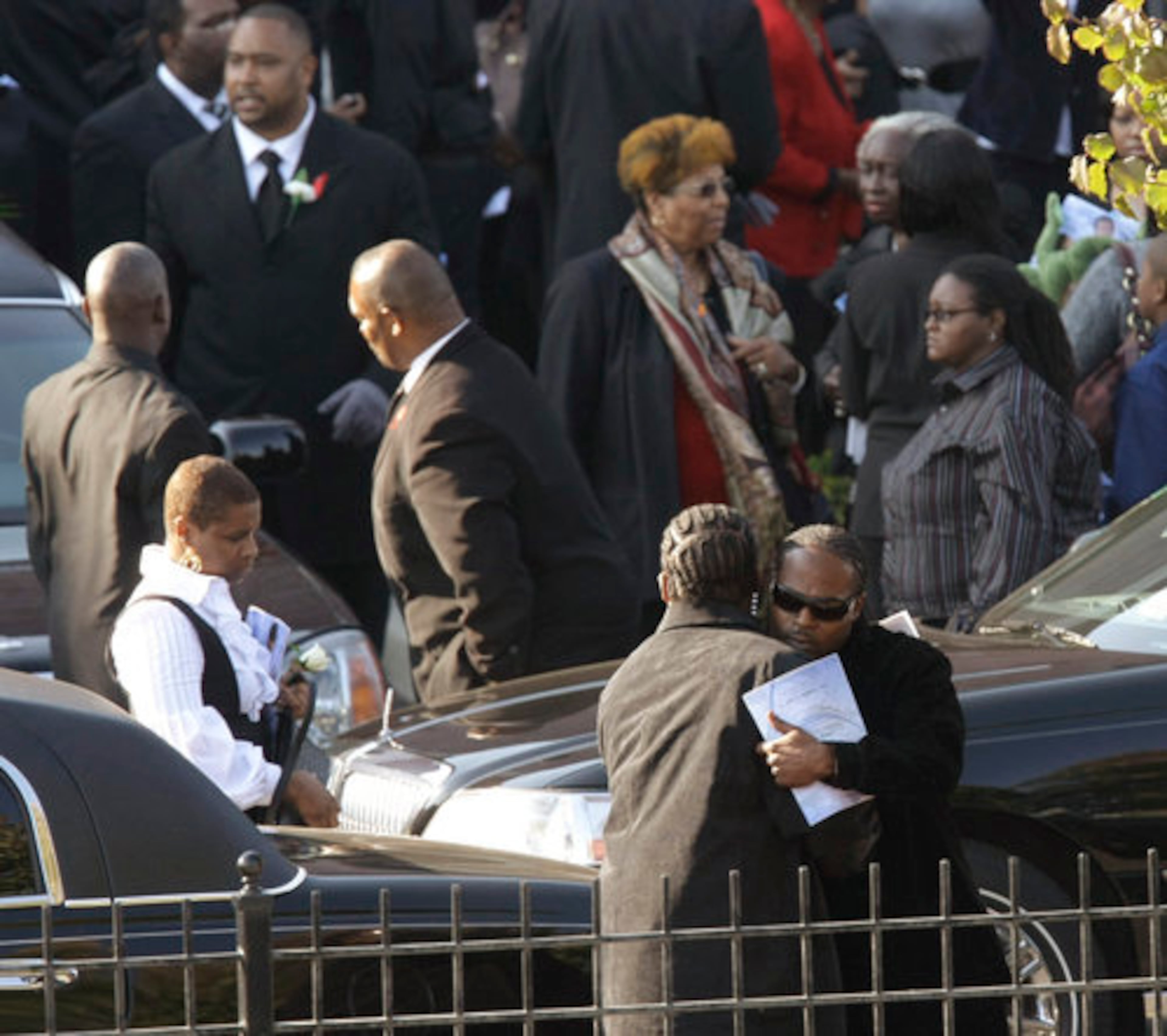 Two men embrace after attending the funeral.