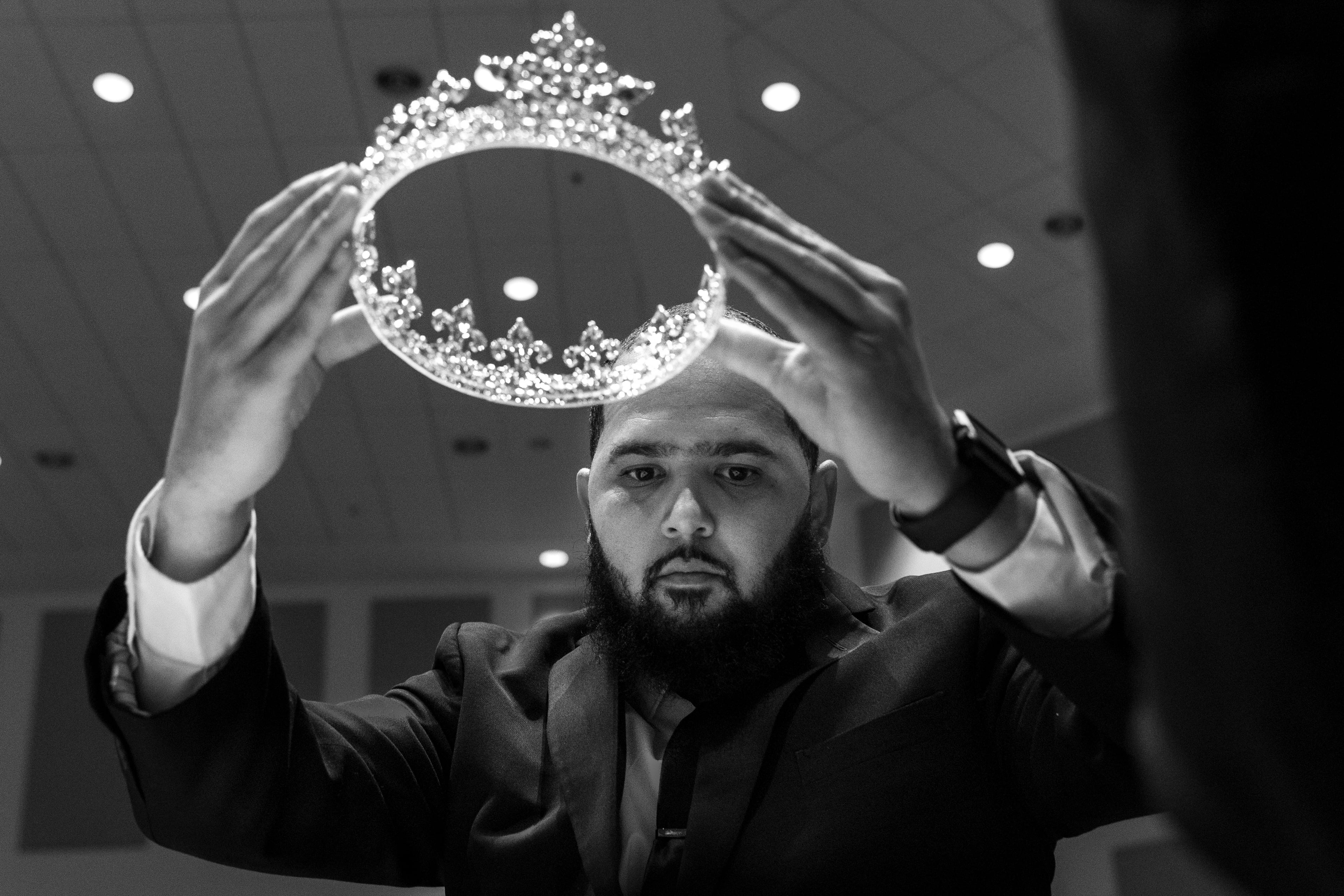 Funeral attendant Preston Hall places a crown on Julian Reeder, as the song “I Shall Wear a Crown” plays.
