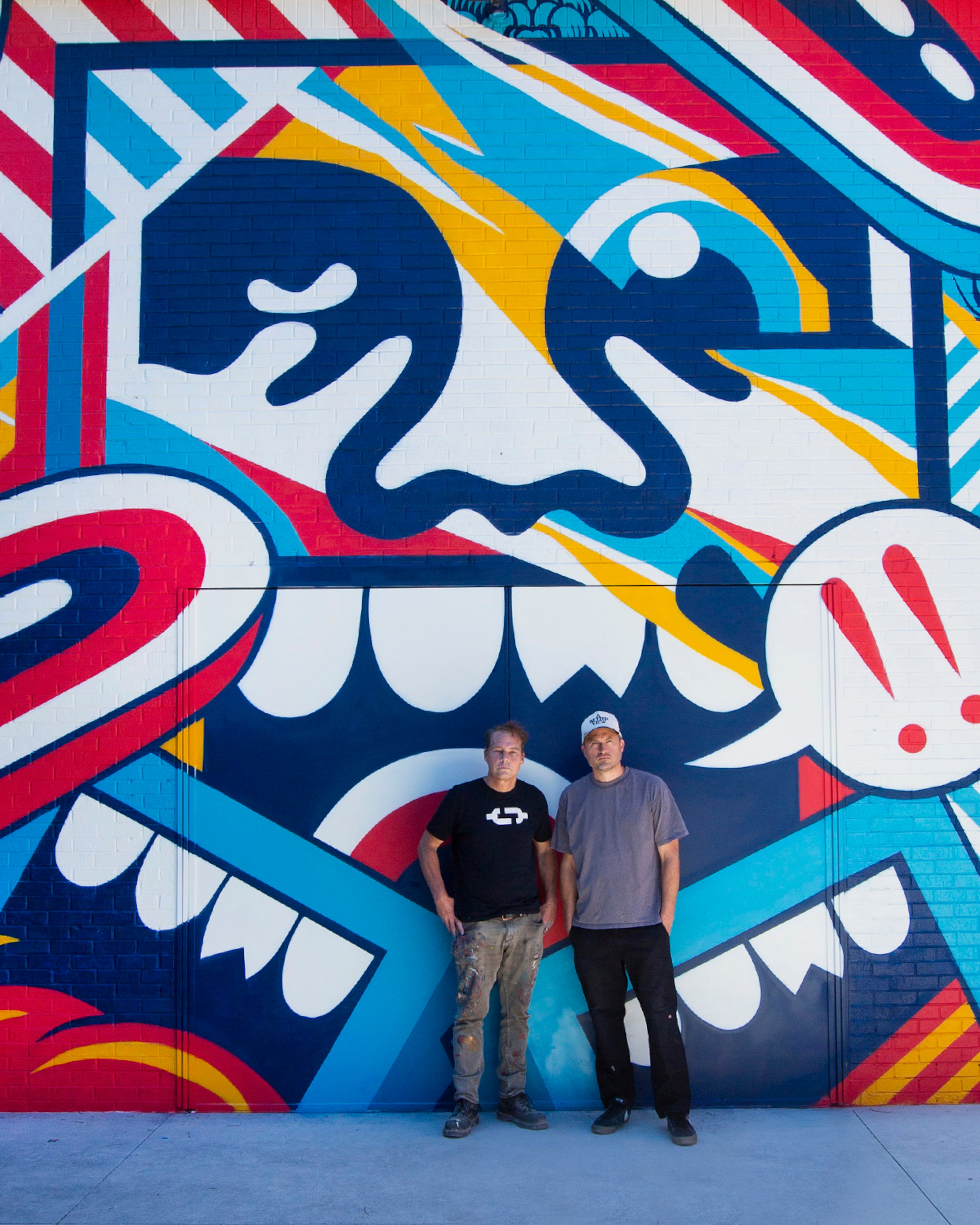 Shepard Fairey (left) and ABV Gallery founder Greg Mike stand in front of the mural they collaborated on in the gallery's Art Yard. (Courtesy of ABV Gallery)