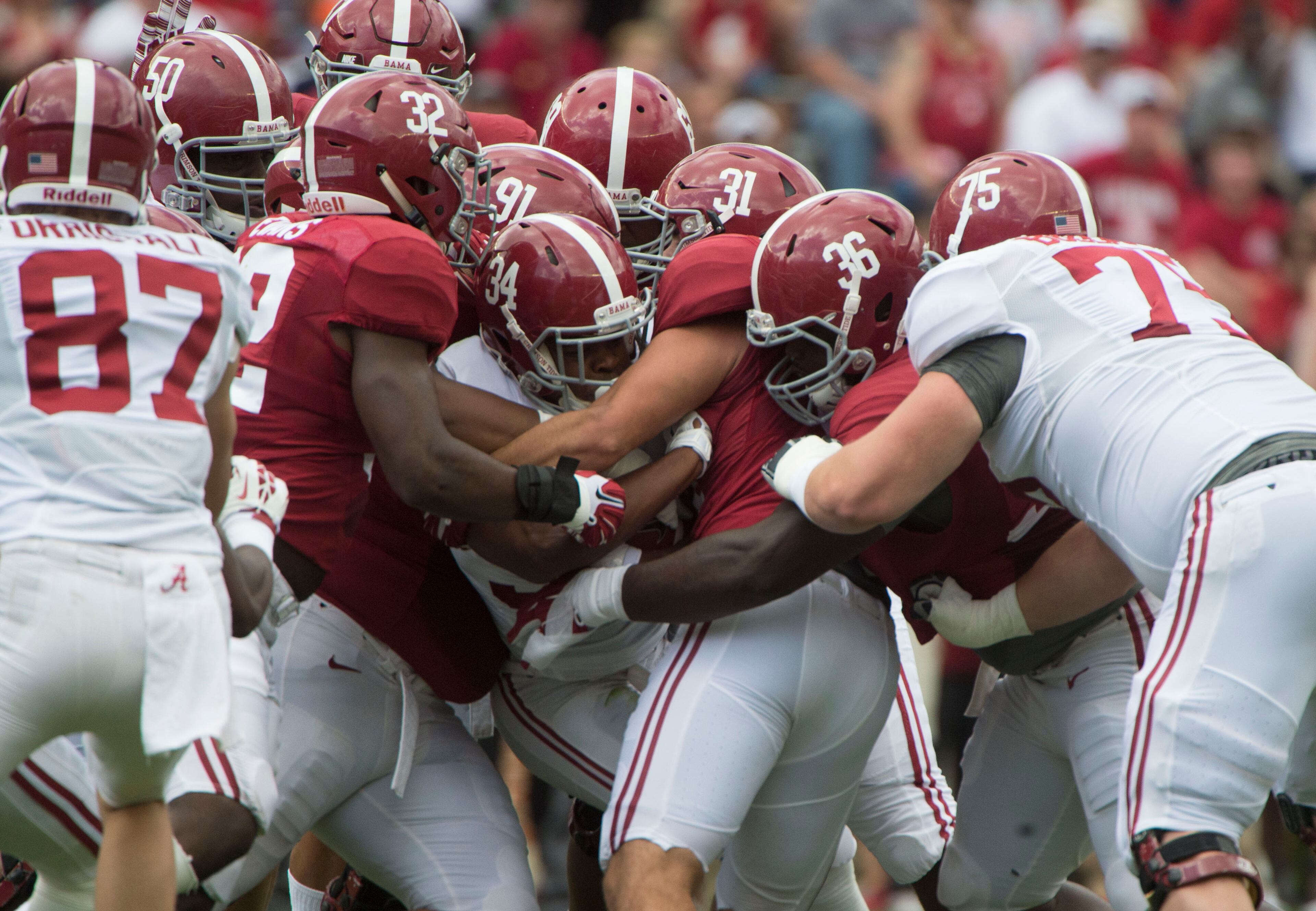 Alabama running back Damien Harris (34) gets wrapped up by linebacker Rashaan Evans (32), linebacker Keaton Anderson (31) and others during the first half of the NCAA college football team's A-Day spring game, Saturday, April 16, 2016, in Tuscaloosa, Ala. (Vasha Hunt/AL.com via AP)