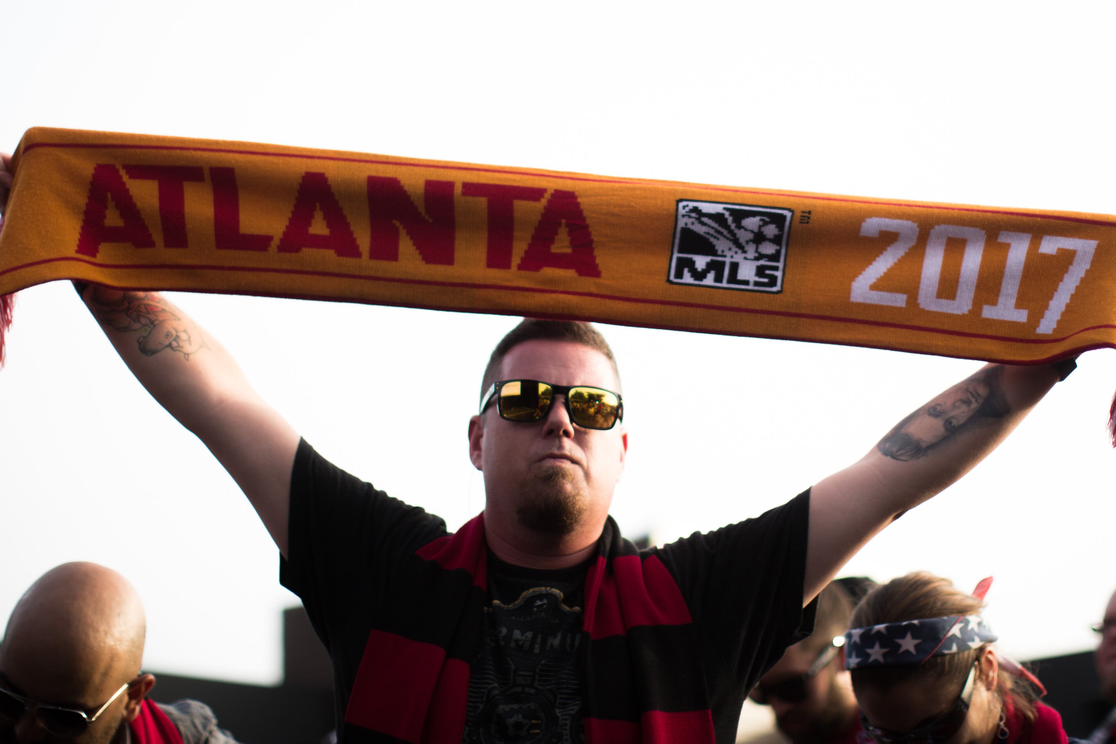 A fan holds a scarf during a party at which Atlanta United FC was announced as the name of an MLS soccer expansion team, Tuesday, July 7, 2015, in Atlanta. The team is scheduled to begin to play in 2017 at the city's new retractable-roof stadium. (AP Photo/Branden Camp)