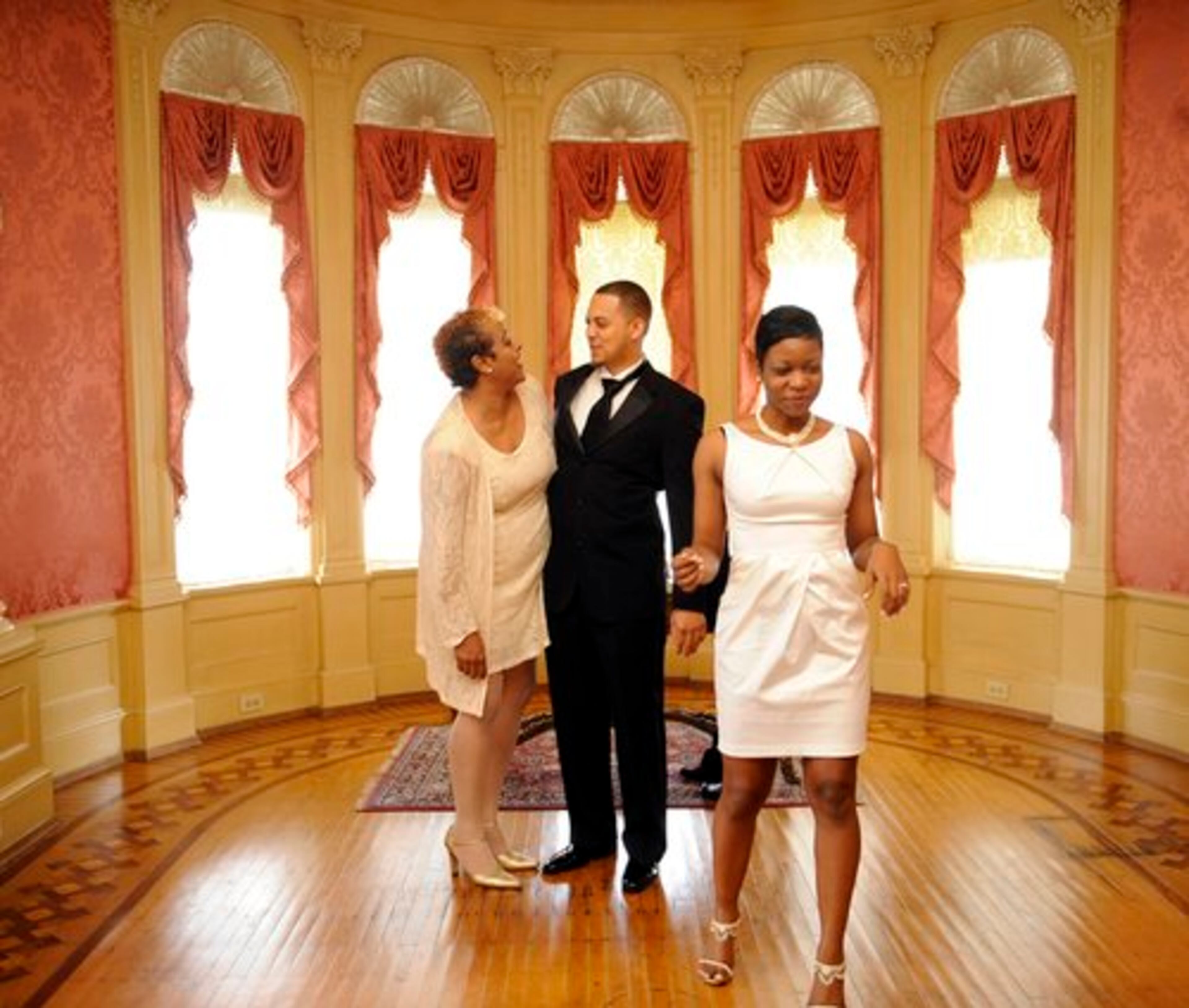 Groom Clarence Lammie (center) is greeted by his new mother-in-law Ramona Hardaway. He and Ashely Lammie (right) were among the 25 couples who exchanged vows at Rhodes Hall - at 15 minute intervals - as part of Cupid at the Castle.