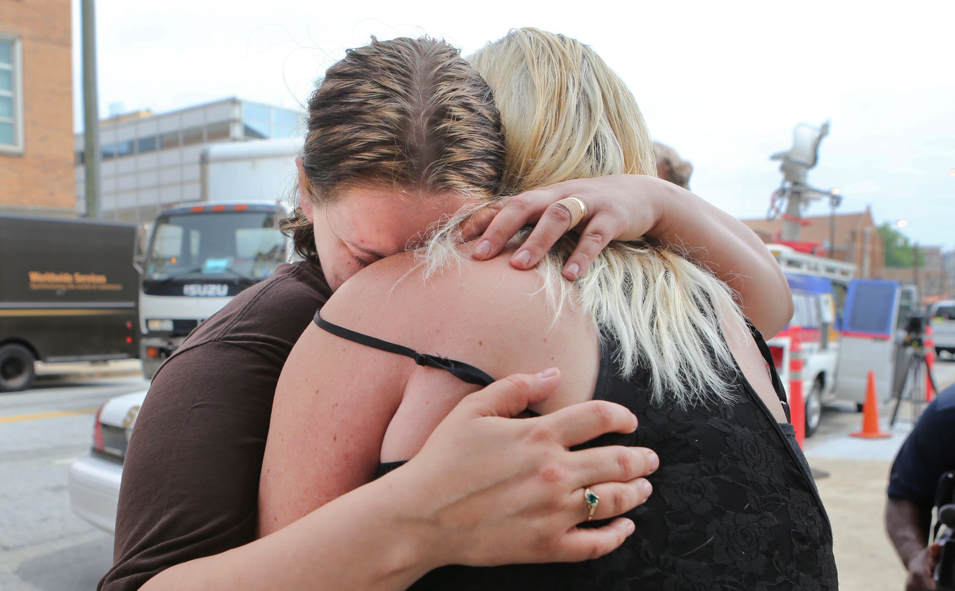 Alecia Phonesavanh (left), the mother of a 19-month-old boy critically injured when a police device was tossed into his bed in Habersham County this week, hugs her mother, Marlene Haygood, outside Grady Memorial Hospital in Atlanta, where they discussed the incident Friday.