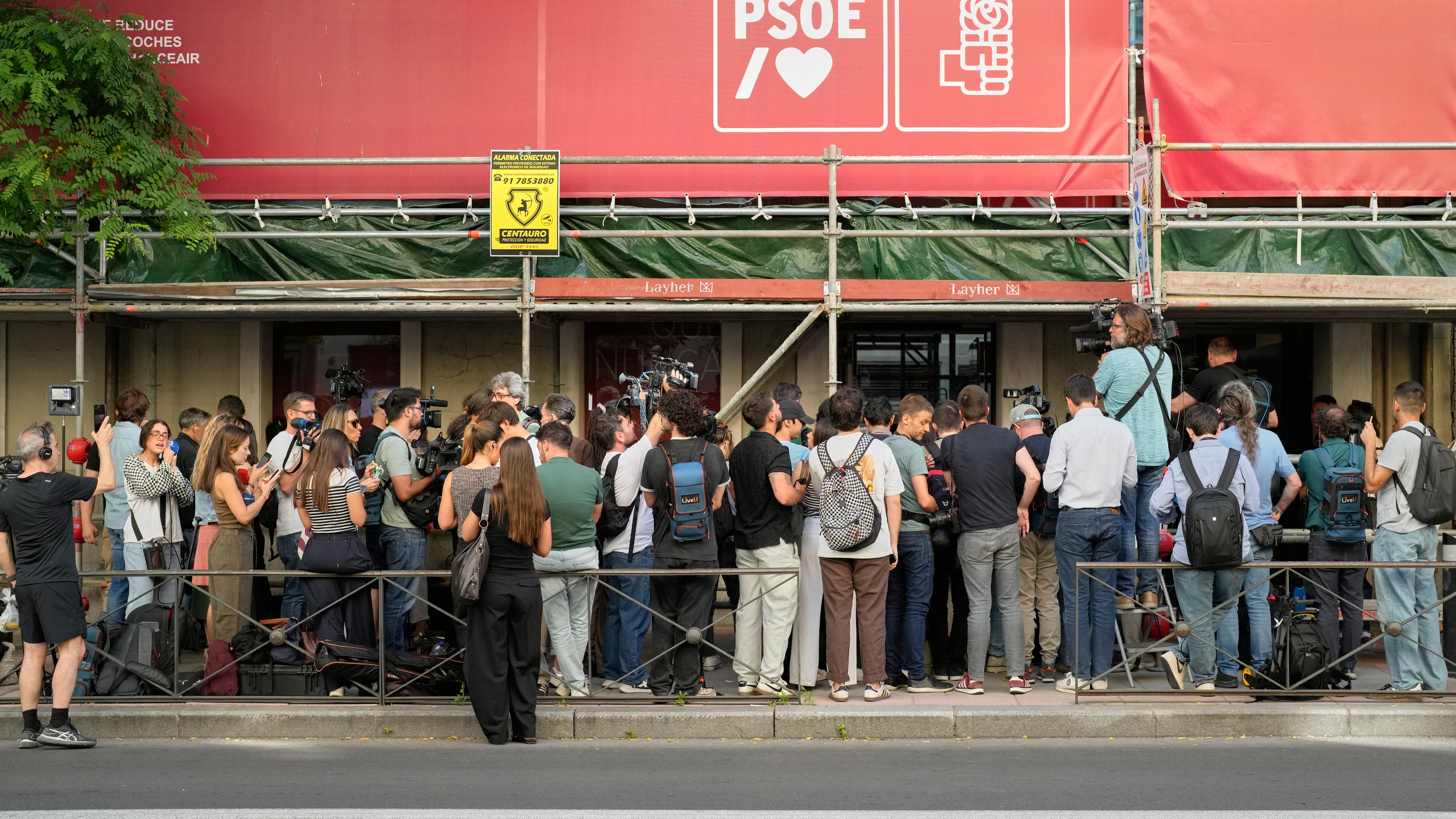 Journalists gather outside the headquarters of Spain's ruling Socialist Party as police search the building in Madrid, Wednesday, May 27, 2026. (AP Photo/Bernat Armangue)