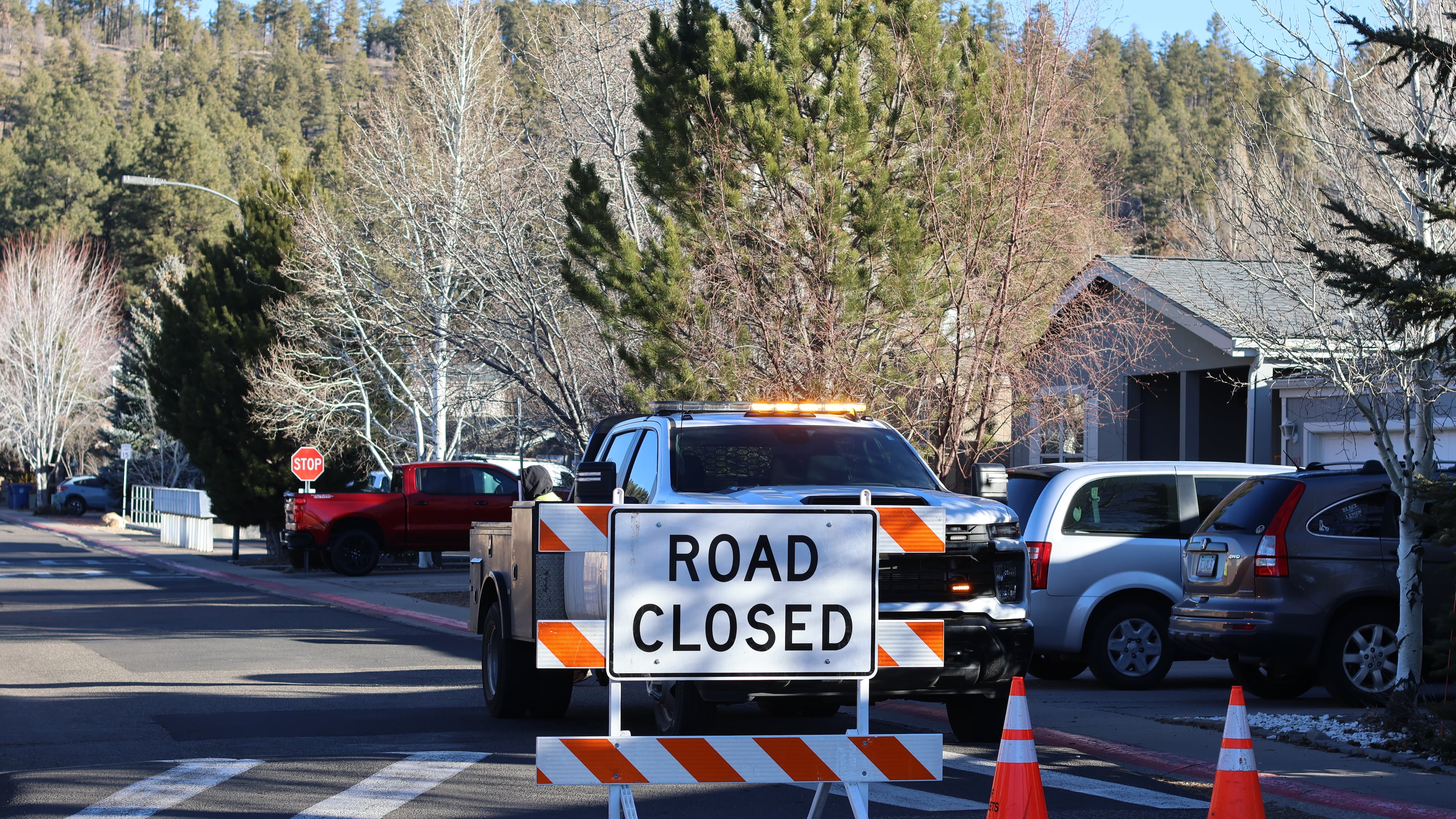 The blocked road to a neighborhood in Flagstaff, Arizona, where police say a man opened fire at officers is seen Thursday, Feb. 5, 2026. (AP Photo/Cheyanne Mumphrey)