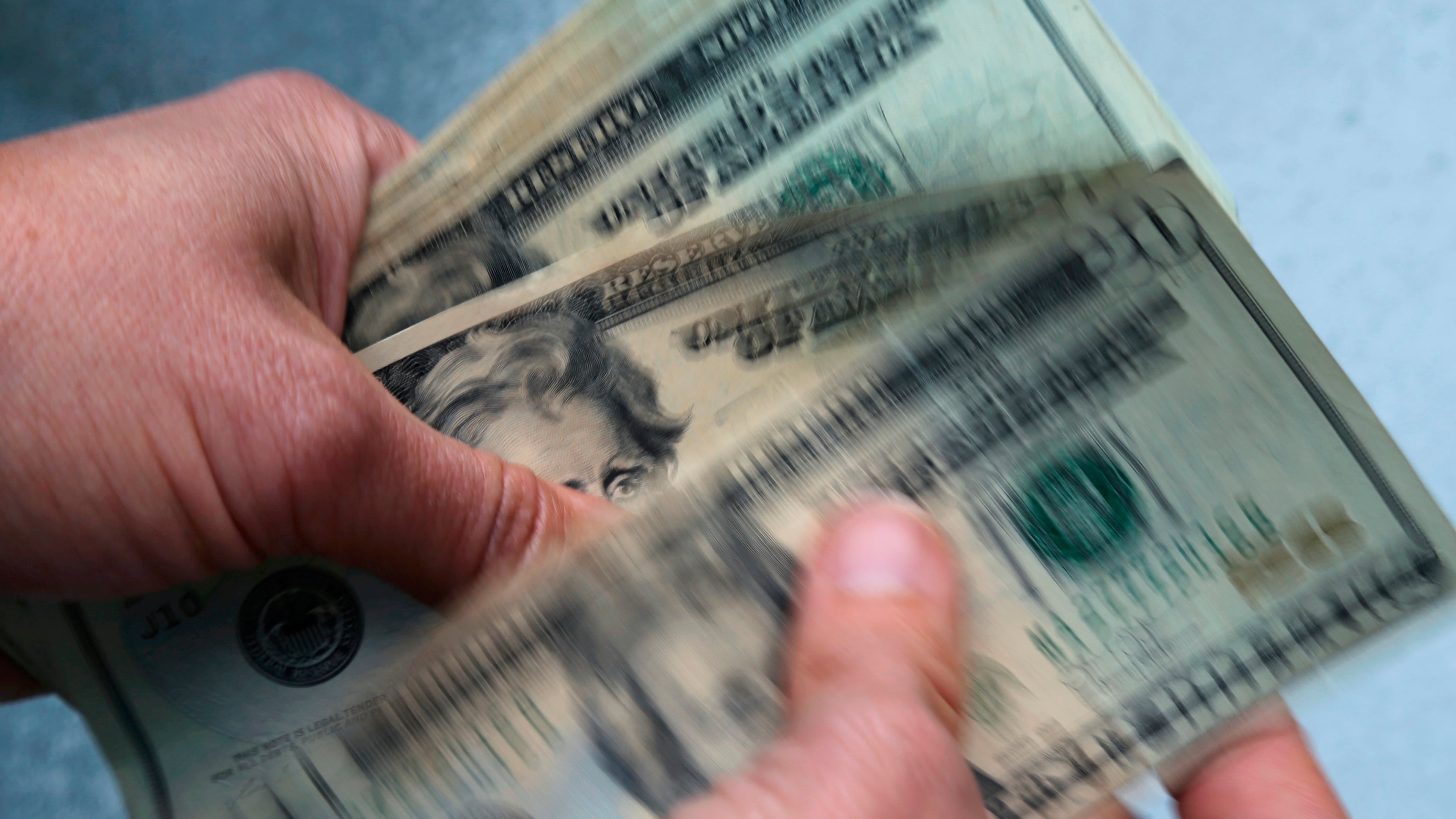 FILE- In this June 15, 2018, file photo, twenty dollar bills are counted in North Andover, Mass. (AP Photo/Elise Amendola, File)