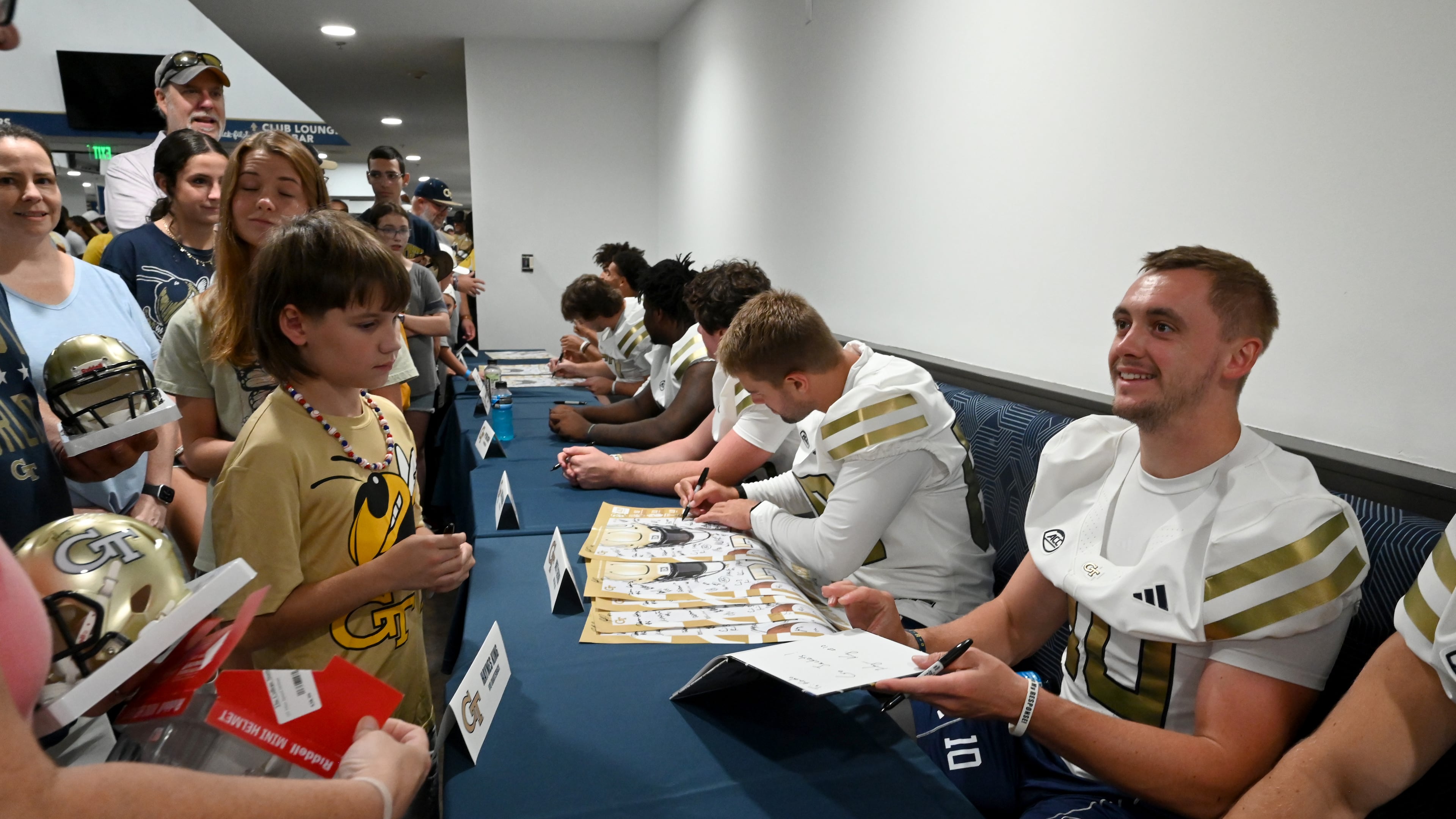 Georgia Tech quarterback Haynes King smiles as he and other players sign autographs for event attendees during the annual “First Saturday on The Flats” at Bobby Dodd Stadium, Saturday, Aug. 2, 2025, in Atlanta. (Hyosub Shin/AJC)