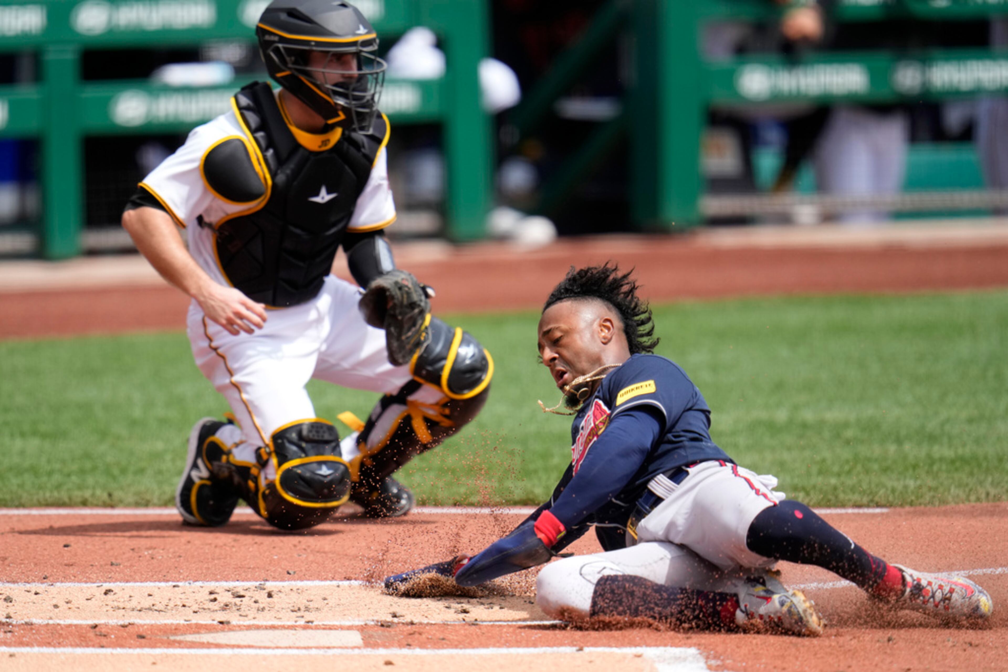 Atlanta Braves' Ozzie Albies, right, scores past Pittsburgh Pirates catcher Jason Delay on a single by Austin Riley off Pirates starting pitcher Bailey Falter during the first inning of a baseball game in Pittsburgh, Thursday, Aug. 10, 2023. (AP Photo/Gene J. Puskar)