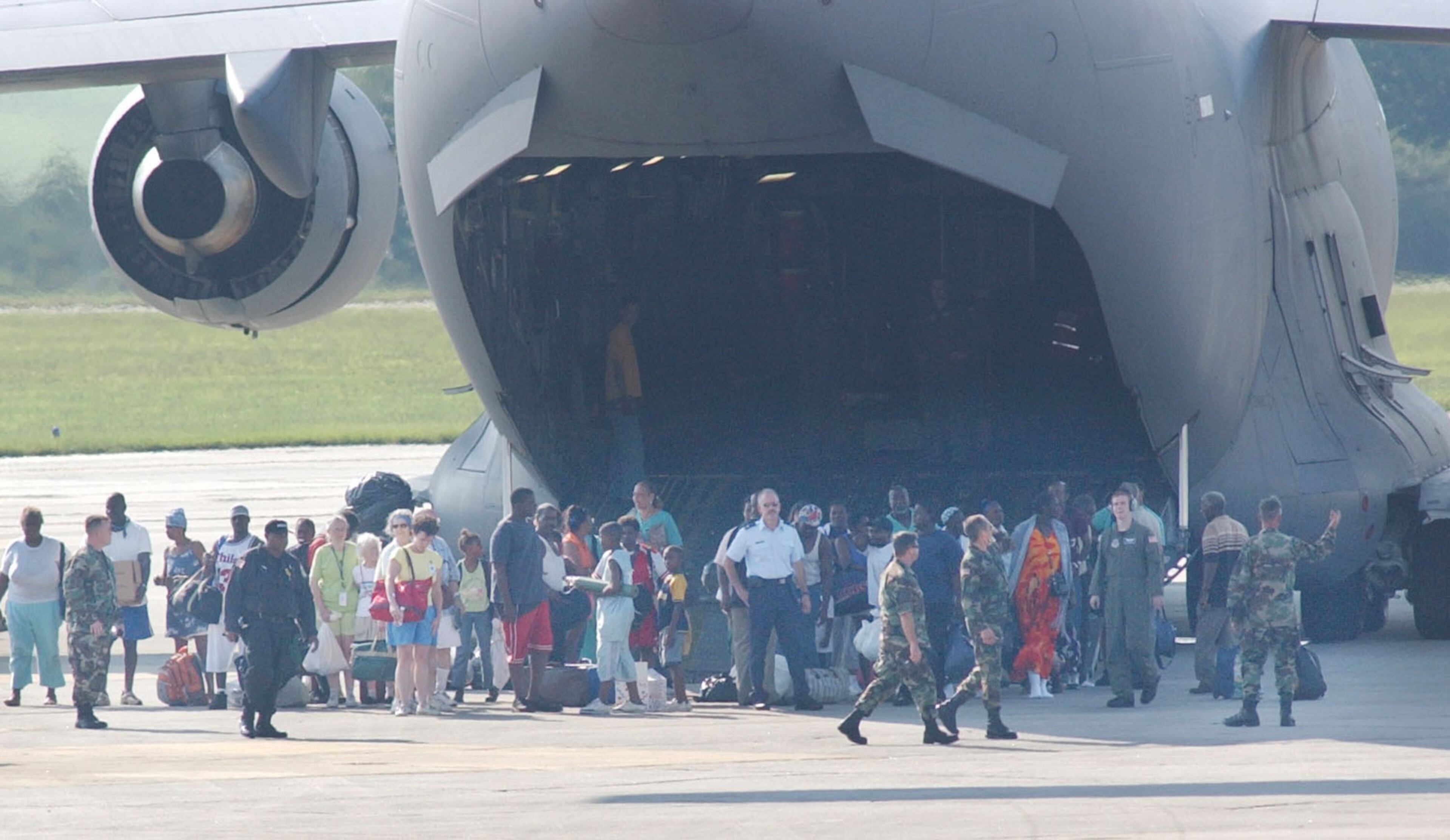 0500901 MARIETTA, GA (cobb): In a Thursday 9/1/05 photo a group of Hurricane Katrina evacuees from New Orleans arrive via military transport plane at Dobbins Air Reserve Base around 5pm. Other planes were coming in throughout the night, some loaded with people in need of medical help, but we were not allowed to photograph the medical plane arrivals. PHOTO BY ANDY SHARP/STAFF.