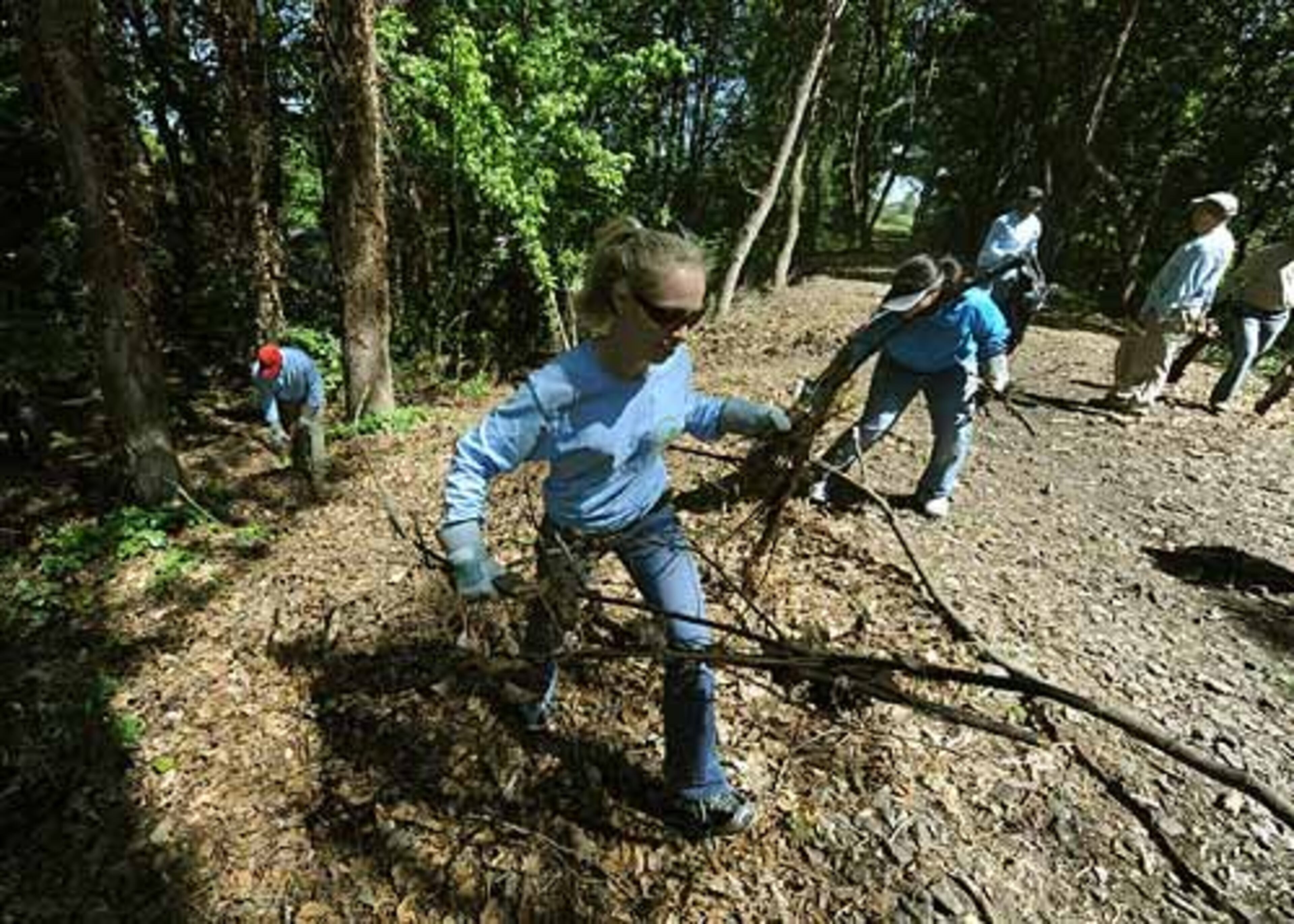 Allison McCouch, of Suwanee, removes branches from the pathway behind the Washington Park Tennis Center.
