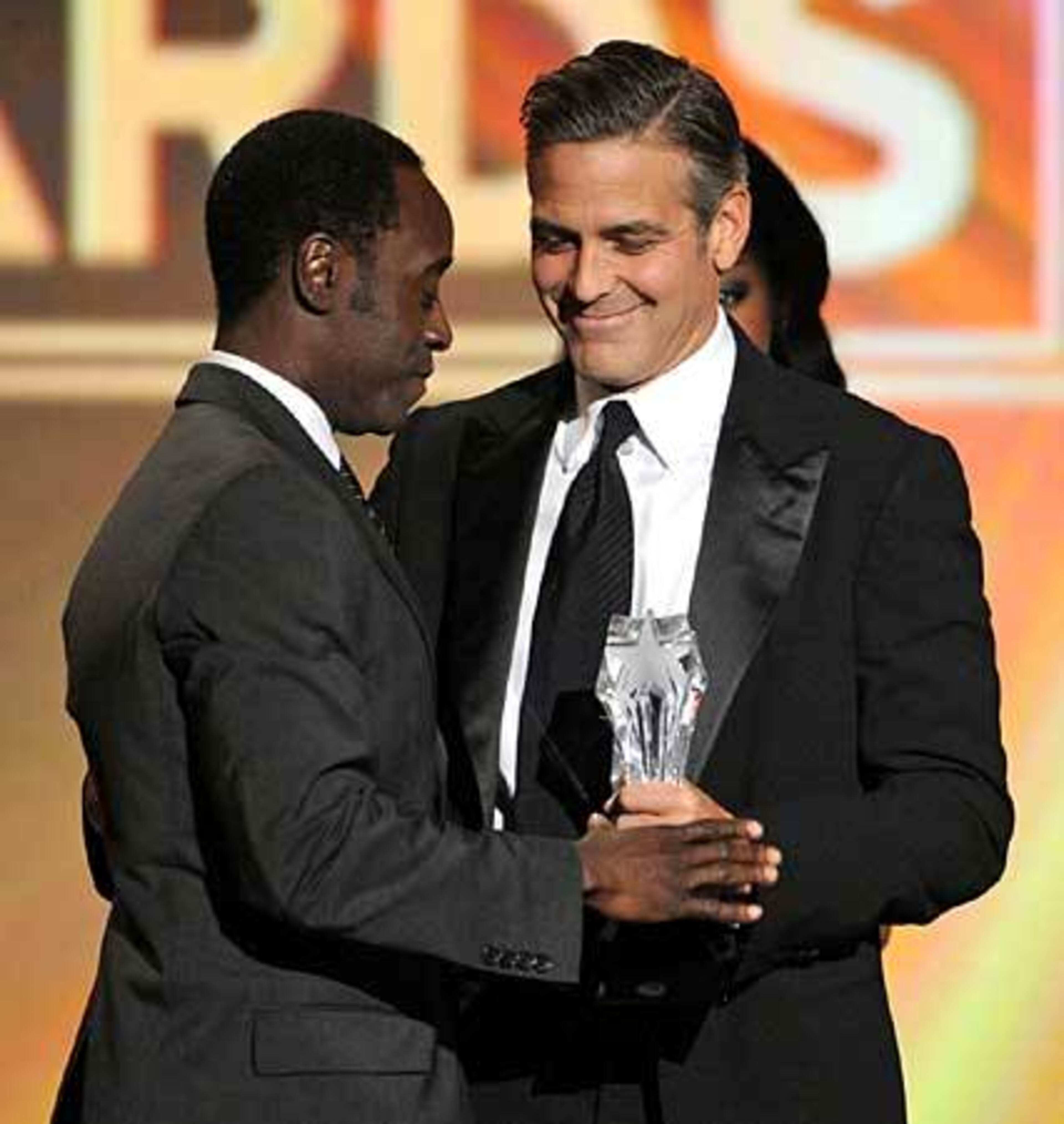 Don Cheadle, left, accepts the Joel Siegel award for humanitarian work from presenter George Clooney.
