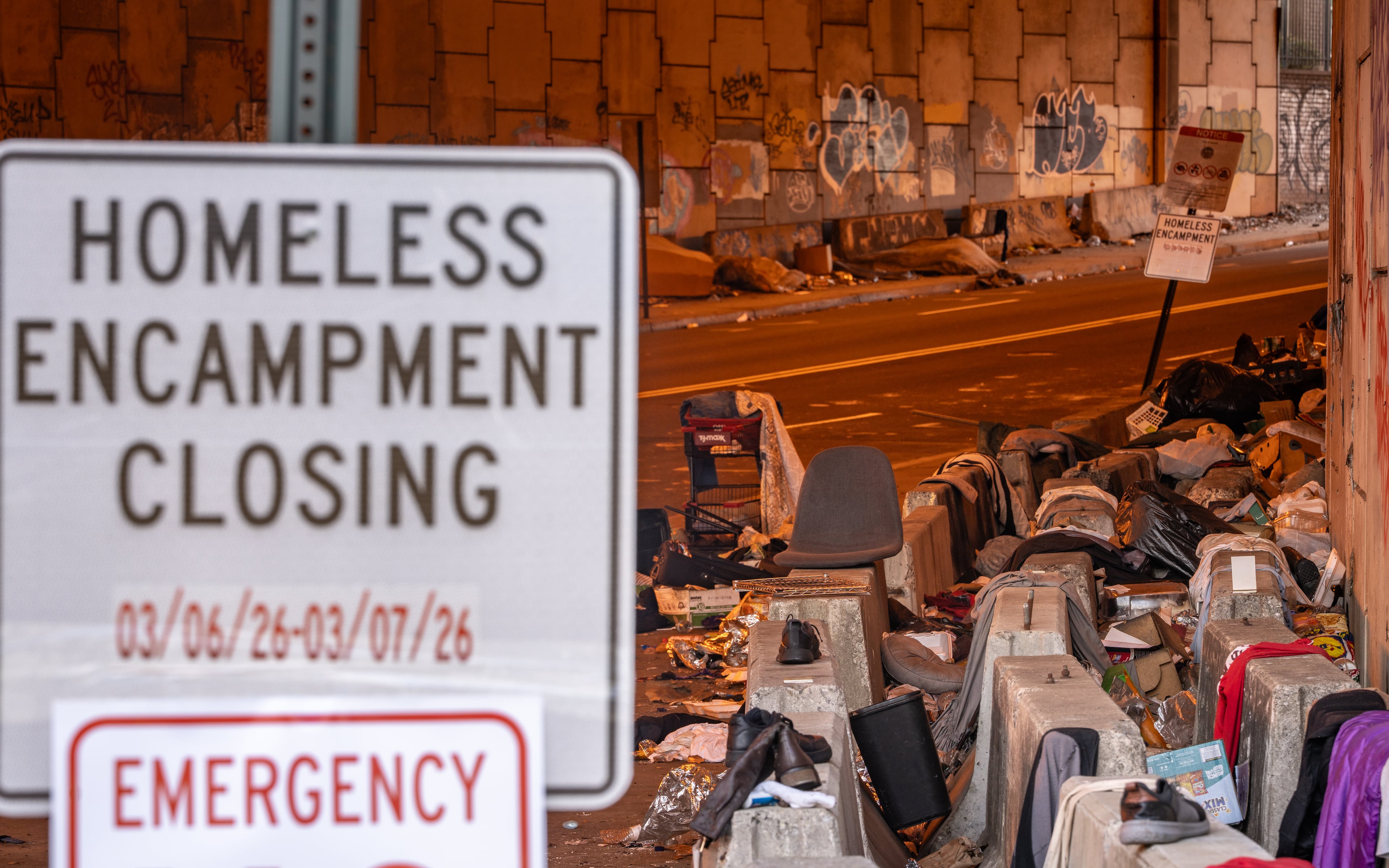 Trash and human waste — including torn clothing and rotting food — is stuck in between concrete barriers at a homeless encampment that runs under I-85 in downtown Atlanta on Friday, March 6, 2026. (Ben Hendren for the AJC)
