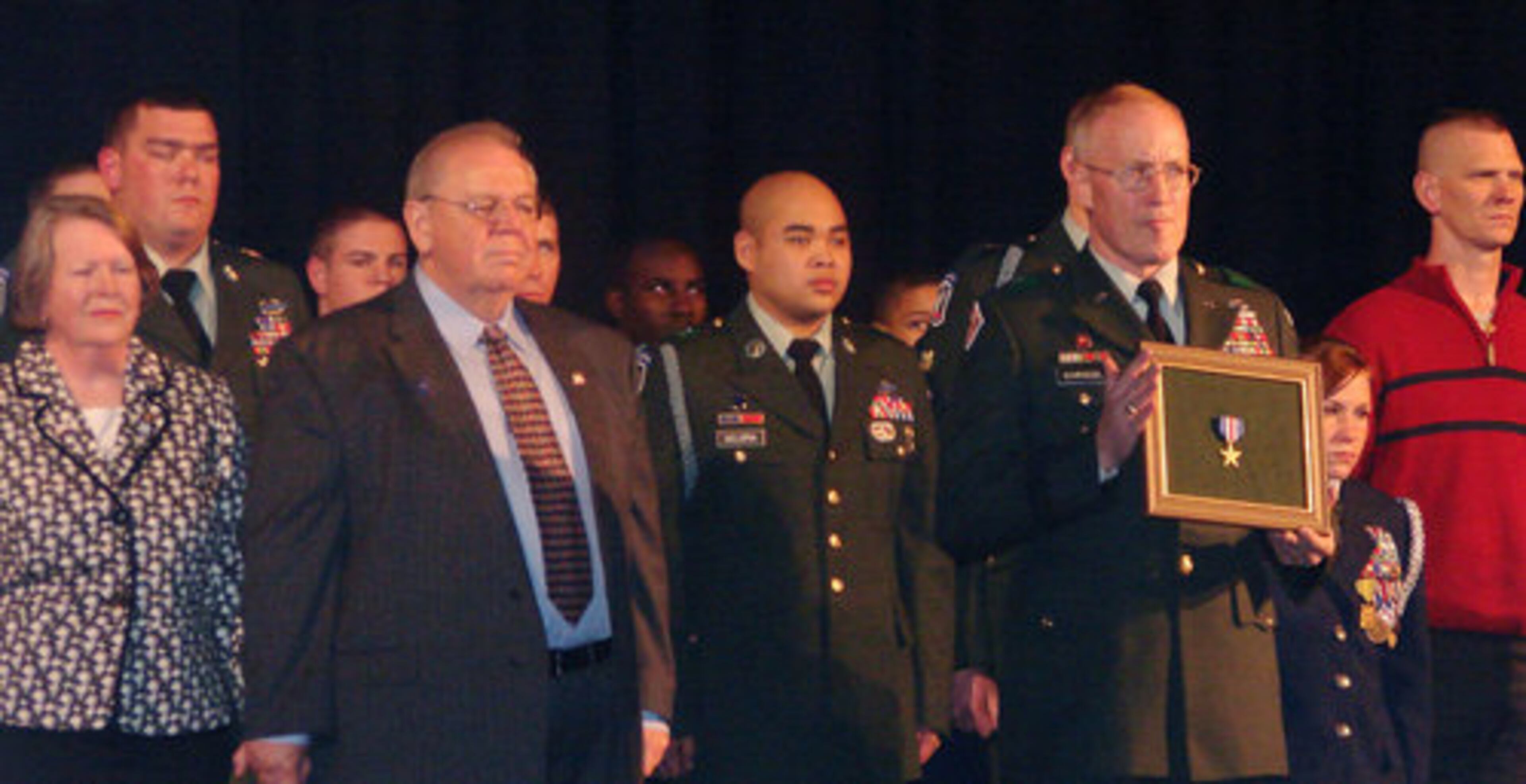 Brig. Gen. Joseph Schroedel holds the Silver Star. At left are Ayers' parents, Suzanne and Bill. Hundreds attended the ceremony at Shiloh High School, where Ayers was an officer in Junior ROTC.