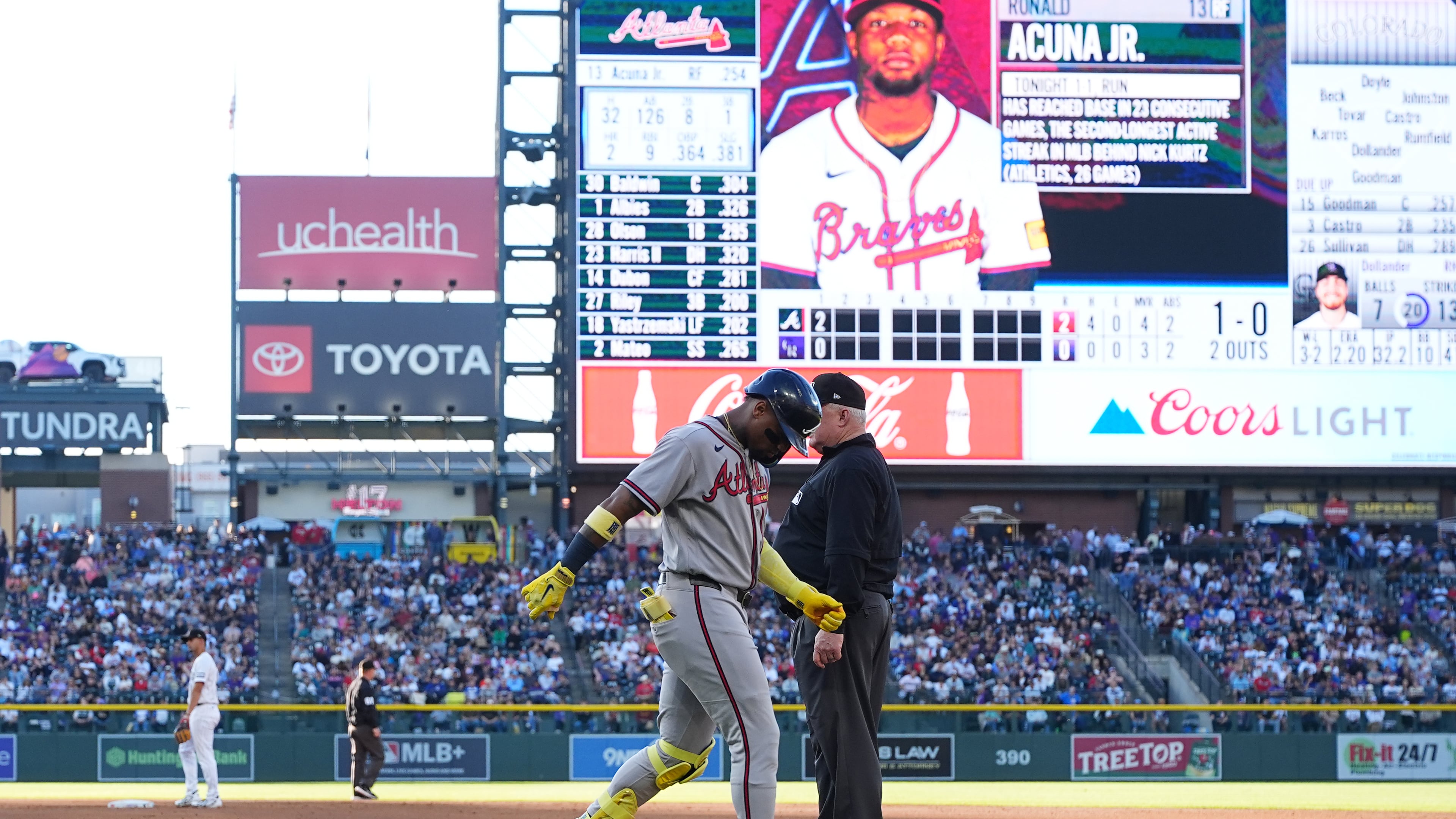 Atlanta Braves' Ronald Acuña Jr., center left, walks gingerly after being injured while running out a groundout as first base umpire Bill Miller, center right, looks on in the second inning of a baseball game against the Colorado Rockies, Saturday, May 2, 2026, in Denver. (AP Photo/David Zalubowski)