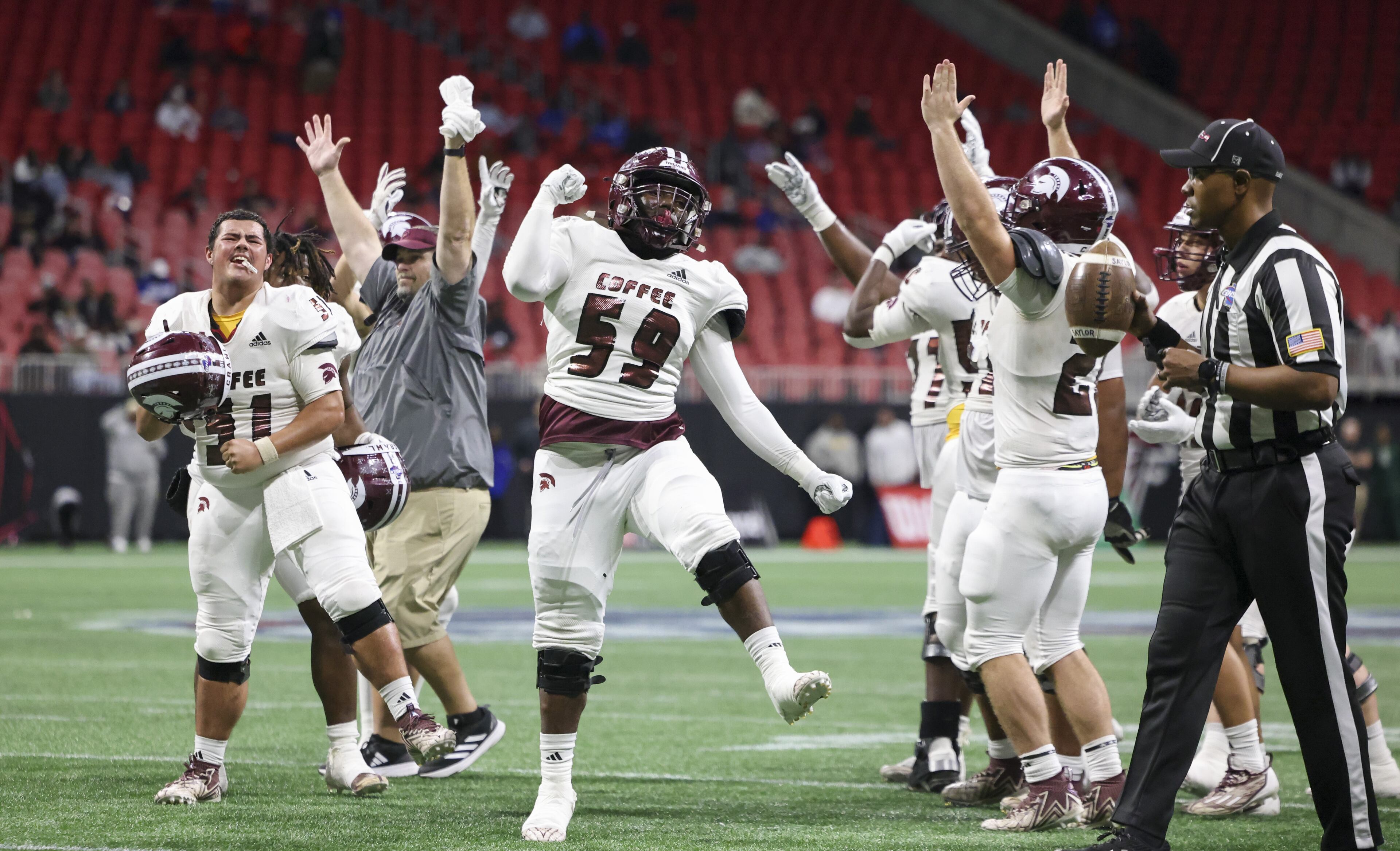 Touchdown: Coffee offensive lineman Jaylon Simpkins (59) and teammates celebrate after Coffee running back Fred Brown (not pictured) scored a touchdown on a reviewed call during the first half against Creekside in the Class 5A GHSA State Championship game at Mercedes-Benz Stadium, Wednesday, December. 13, 2023, in Atlanta. (Jason Getz / Jason.Getz@ajc.com)
