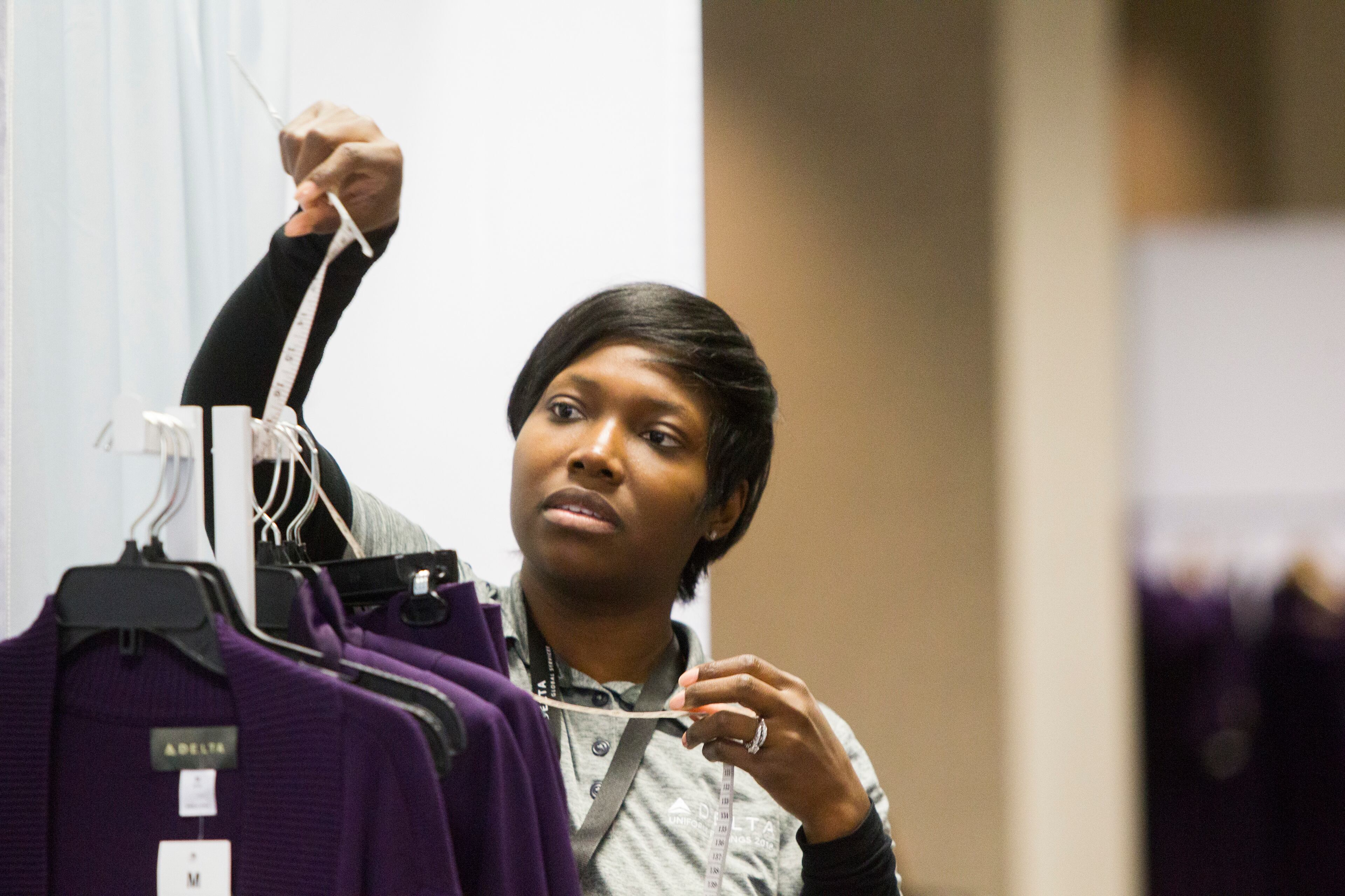 Tiffini Gatlin, a Delta Airlines uniform fitter, adjusts a tape measurer during the uniform fitting for Delta employees at Hartsfield-Jackson Atlanta International Airport in Atlanta, Georgia, on Wednesday, February 7, 2018. (REANN HUBER/REANN.HUBER@AJC.COM)