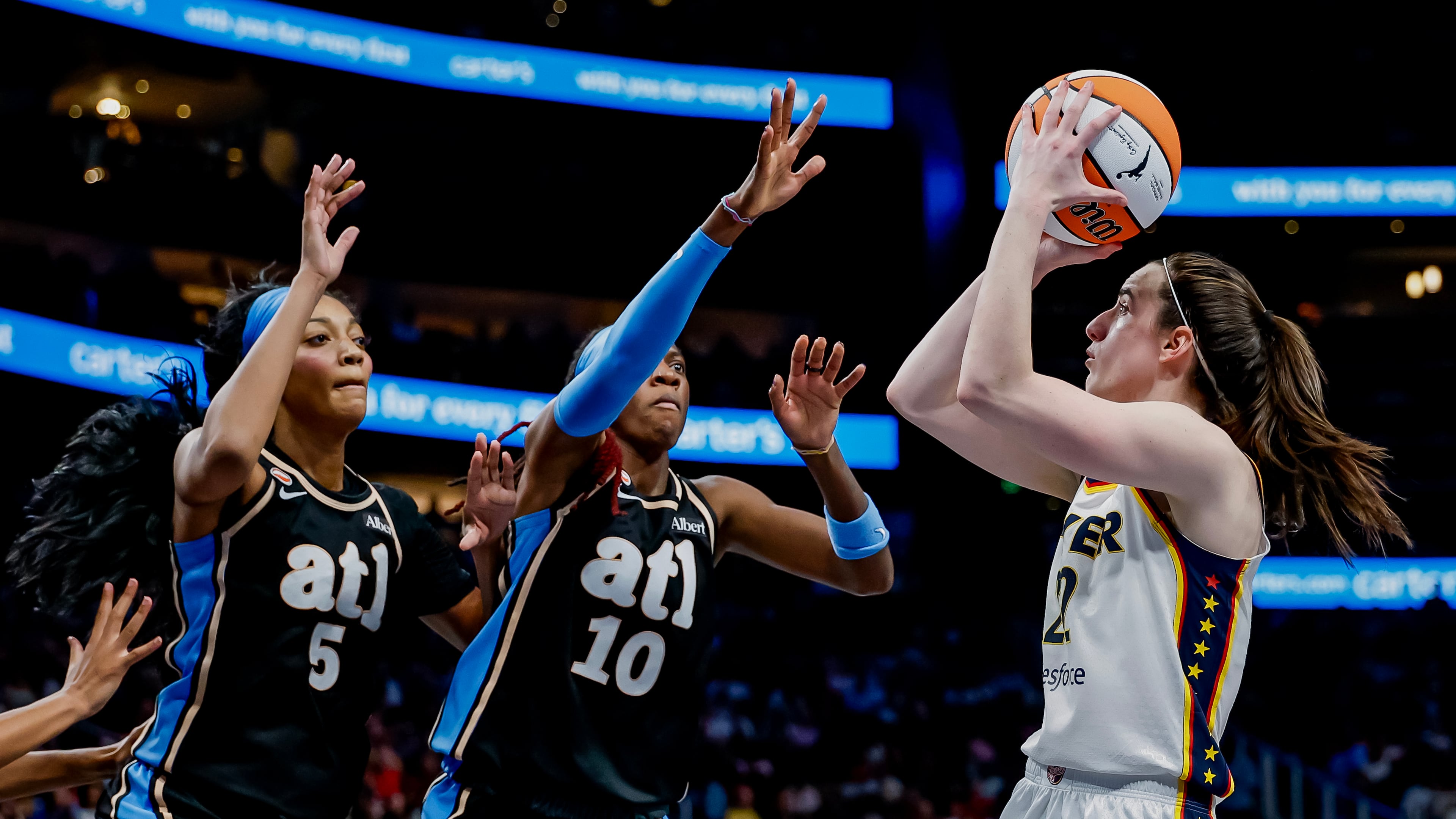 Atlanta Dream forward Angel Reese (left) and guard Rhyne Howard defend against Indiana Fever guard Caitlin Clark during Sunday's WNBA game in Atlanta. (Erik S. Lesser for the AJC)
