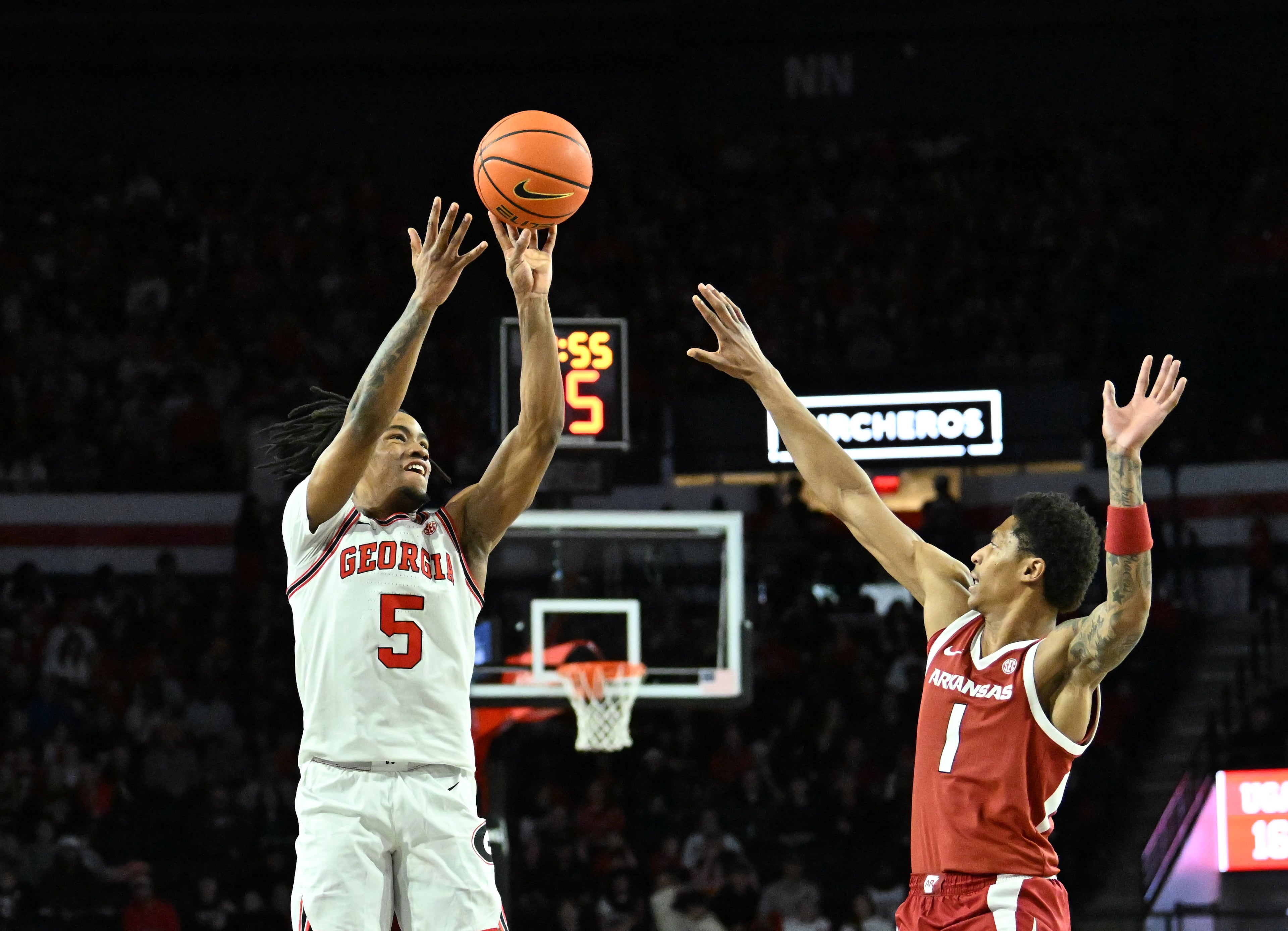 Georgia guard Jeremiah Wilkinson gets off a shot over Arkansas guard Meleek Thomas during the first half in an NCAA college basketball game at Stegeman Coliseum, Saturday, Jan. 17, 2026, in Athens. (Hyosub Shin/AJC)