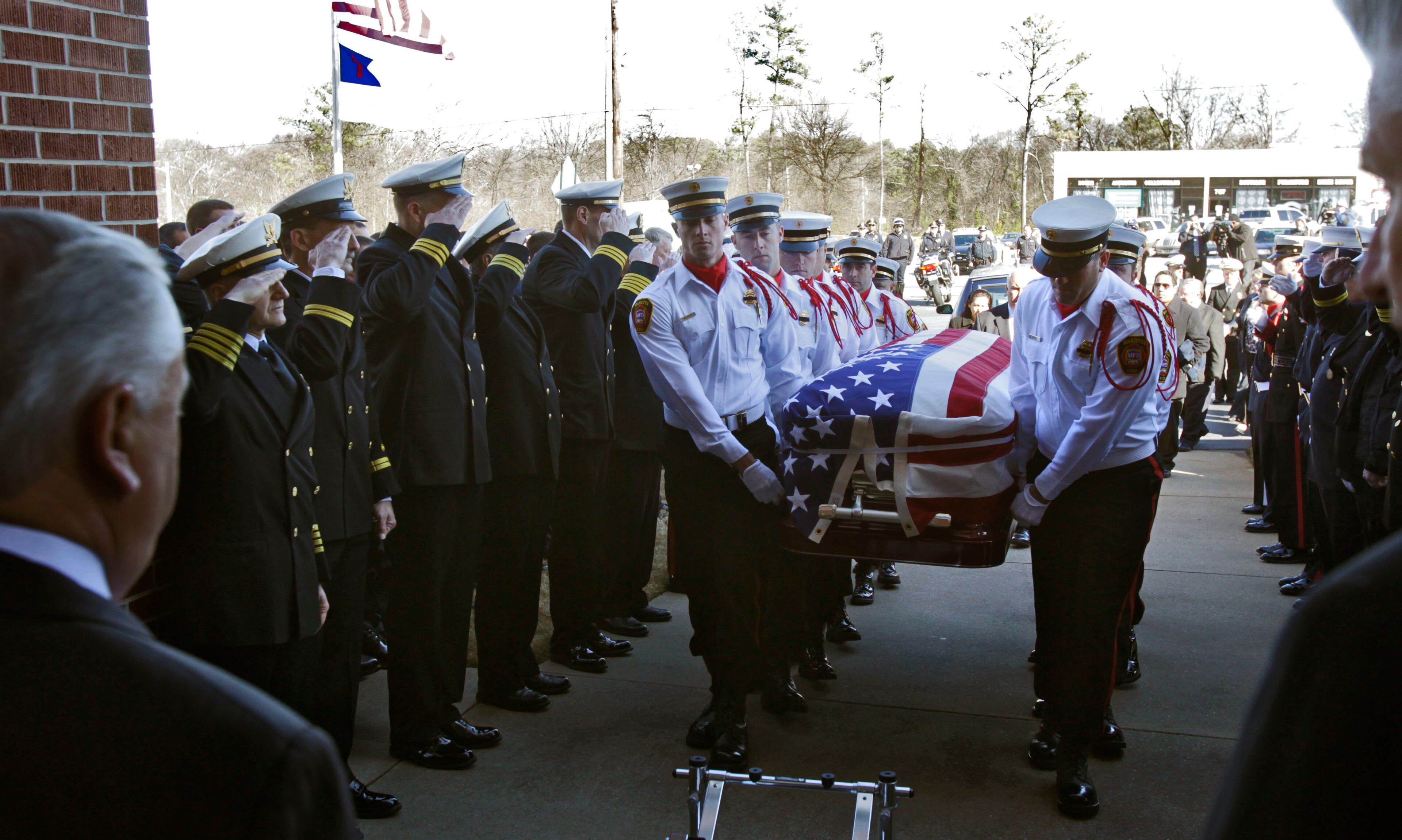 The honor guards salute as pall bearers carry the casket into the church.The funeral for Marietta fire fighter Lonnie Lee Nutt was held today at Roswell Street Baptist Church in Marietta.
