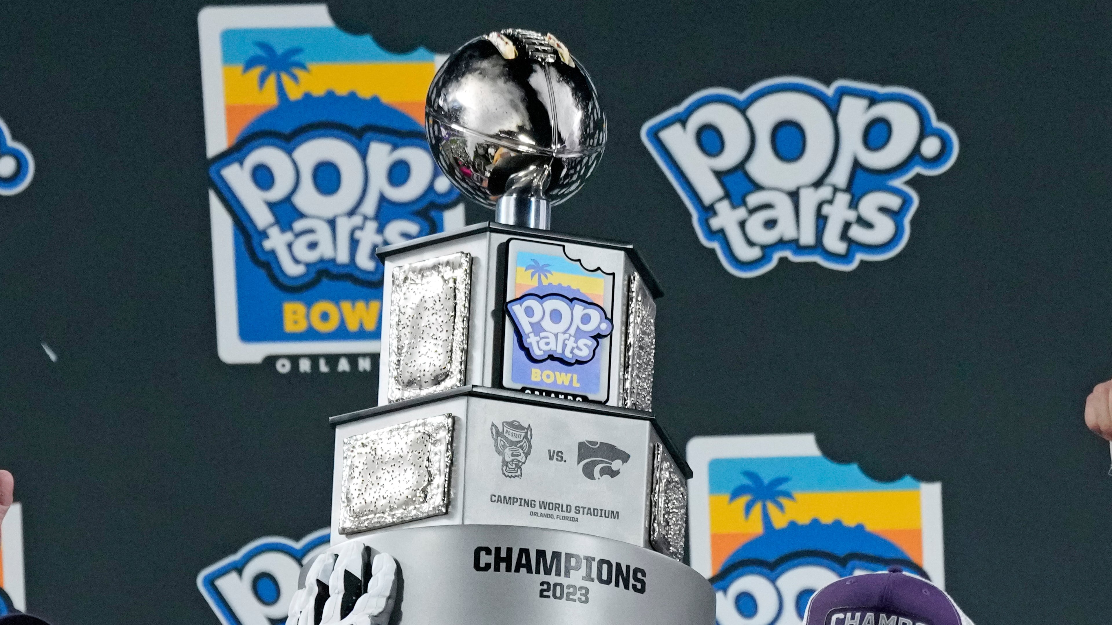 Kansas State players hold up the championship trophy after winning the Pop-Tarts Bowl NCAA college football game against North Carolina State, Dec. 28, 2023, in Orlando, Fla. (John Raoux/AP)
