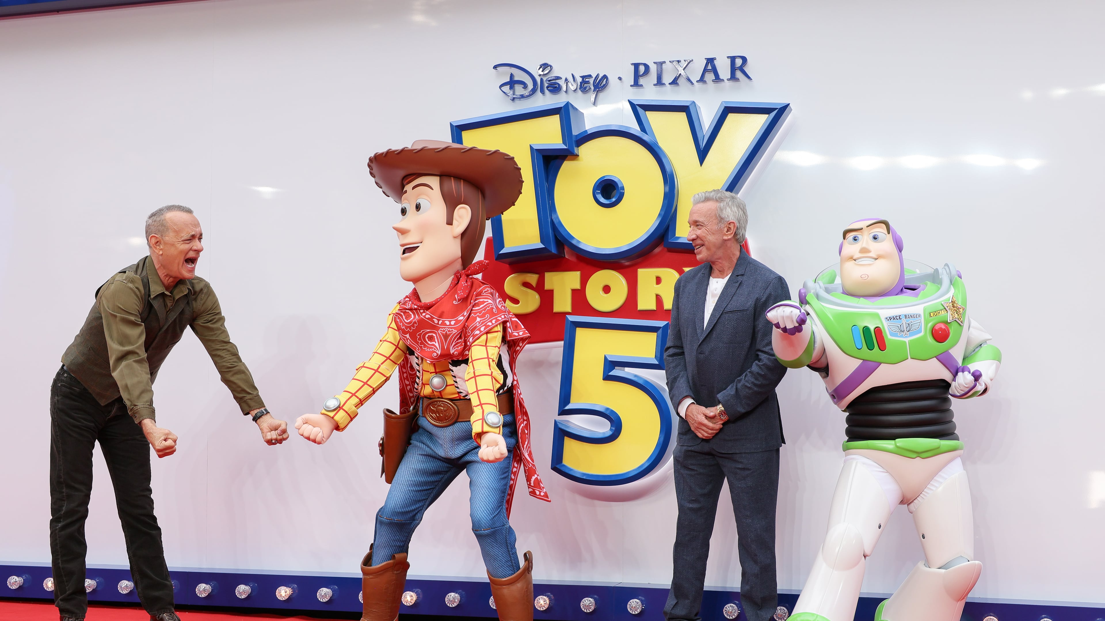 Tom Hanks, left, and Tim Allen pose for photographers with people costumed as the characters Woody and Buzz Lightyear upon arrival at a launch event for the film 'Toy Story 5' on Thursday, May 28, 2026, in London. (Photo by Millie Turner/Invision/AP)