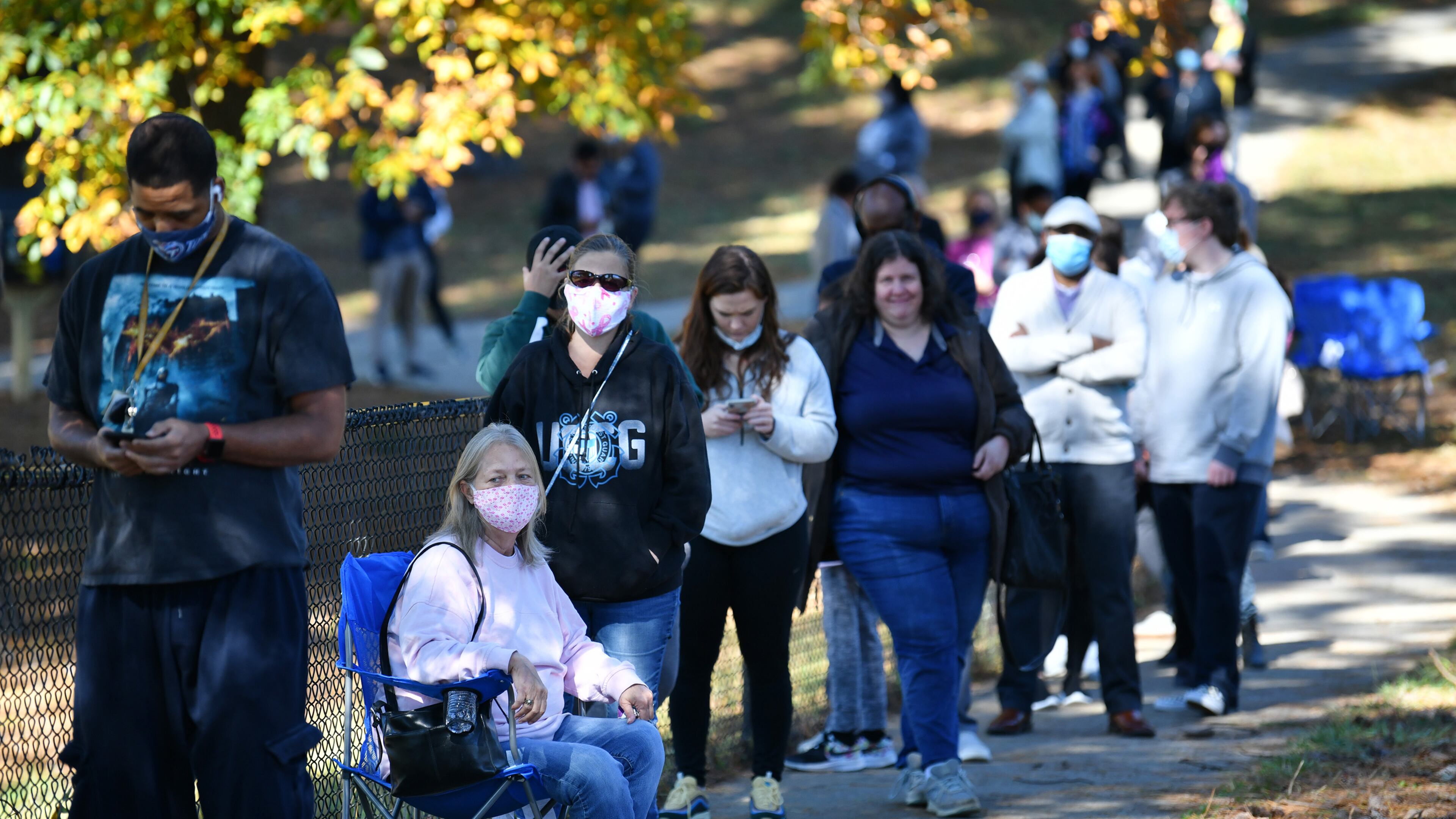 Deborah Wood, sitting on a camping chair, waits in lines to cast a ballot at the Shorty Howell Park Activity Building in Duluth, Georgia, on the last day of early voting on Oct. 30, 2020. (Hyosub Shin/Atlanta Journal-Constitution/TNS)