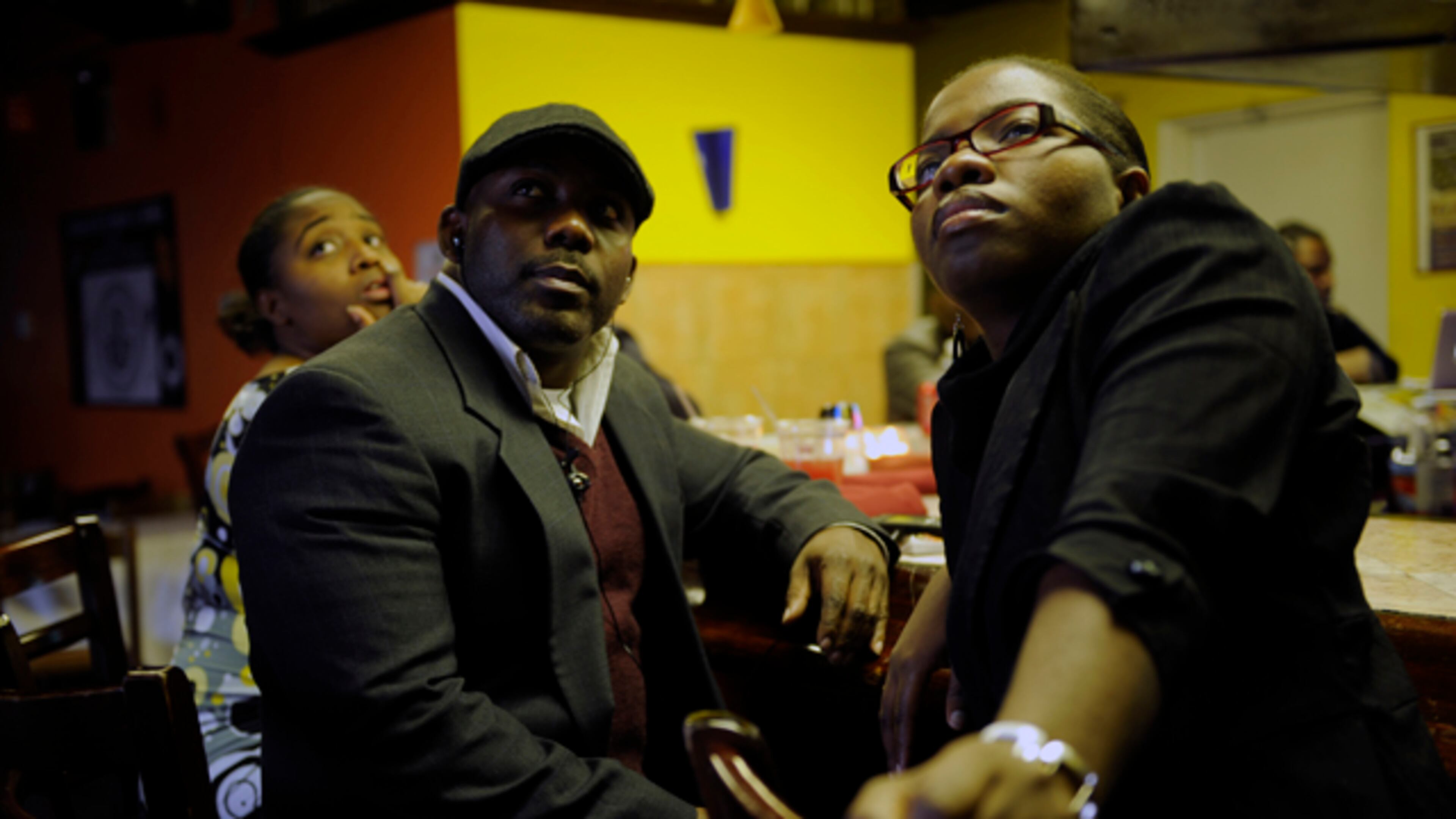 From left, Haitians Kevin Jeudy, 32, of Alpharetta, and Fabiola Guerrier, 26, of Conyers, watch news coverage of the magnitude 7 earthquake that hit their home yesterday at Cafe Fasika in Clarkston, Ga Wednesday, Jan 13, 2010. Guerrien says she came to the United States in 2000 and is still waiting to hear from her family who is still living there.