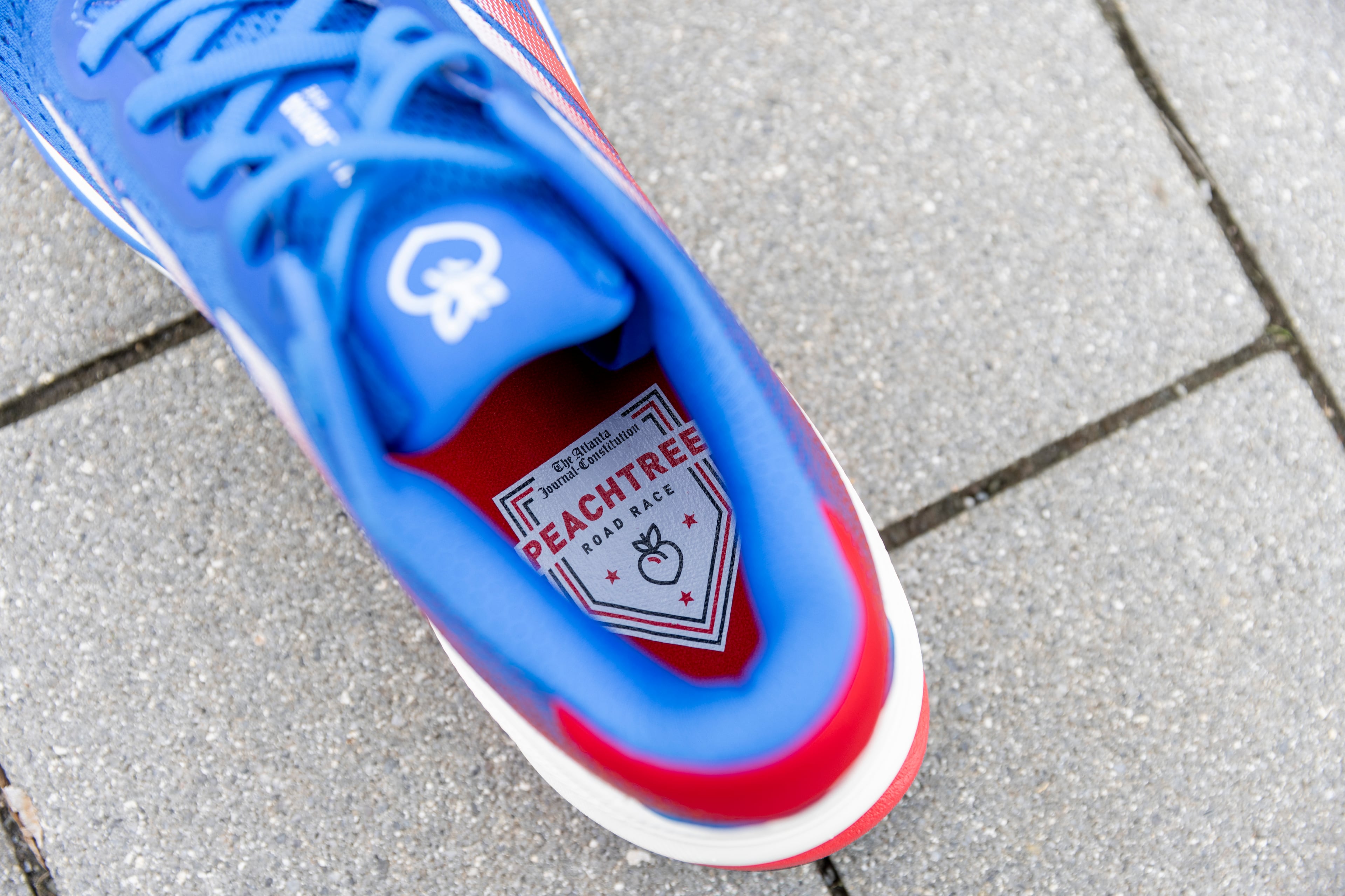 The design includes the race logo inside and a signature peach on the tongue.