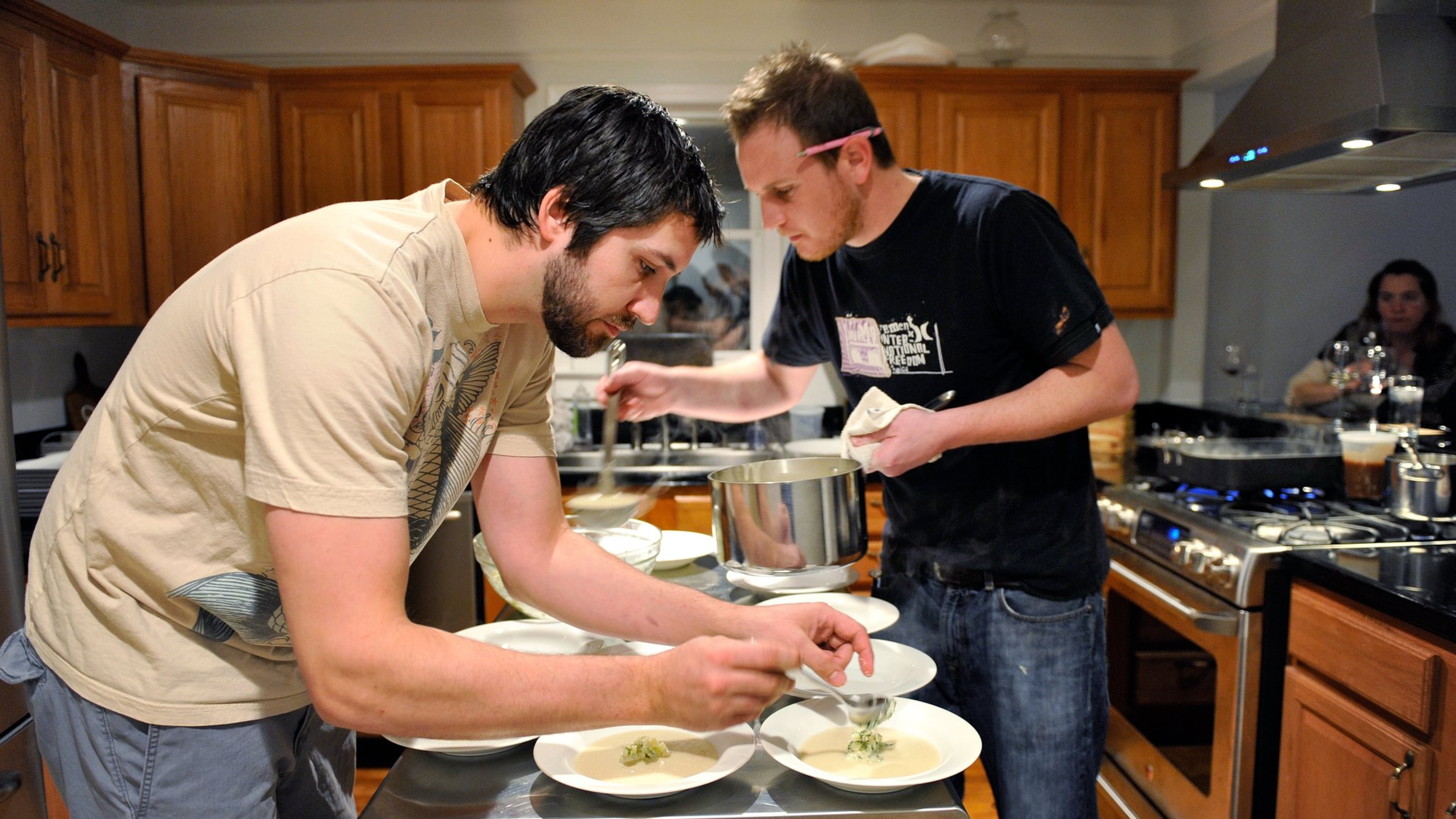 Hidinger (left) and Ben Barth (right) prepare fennel soup with apple relish at the supper club the Hidingers hosted in their Grant Park home in 2010.
