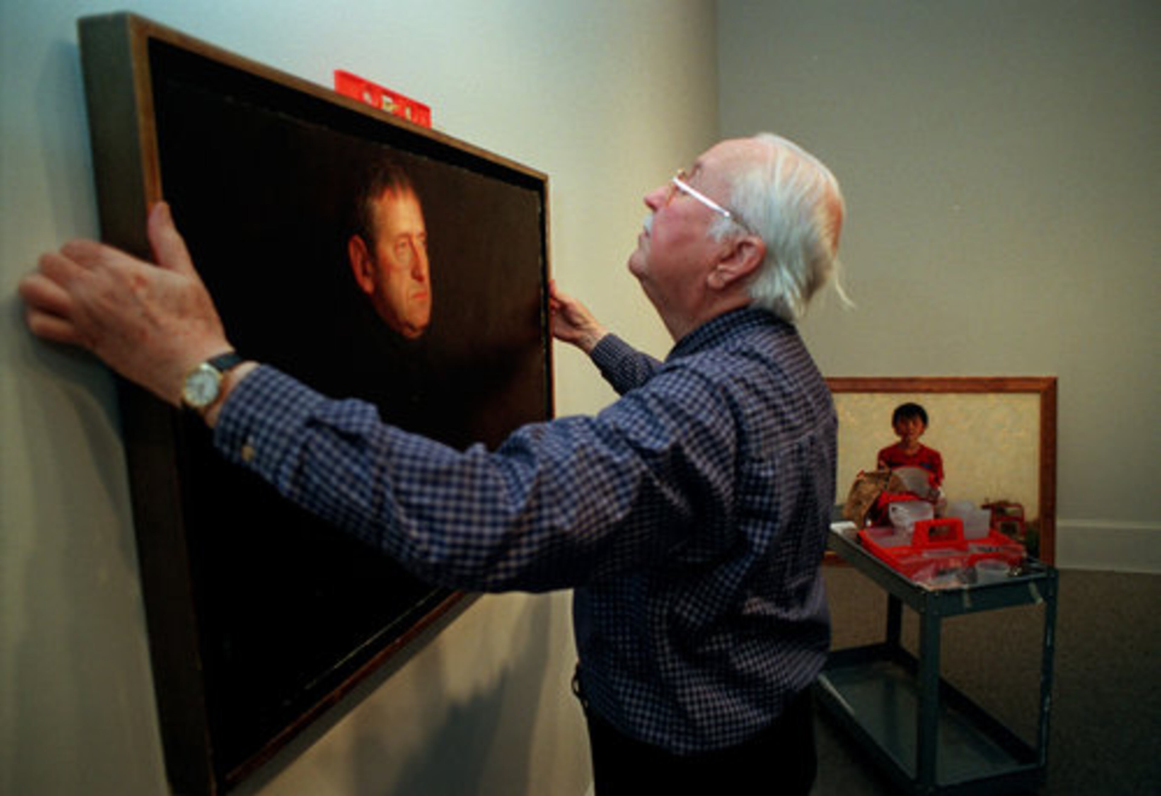 In 1998, the Marietta Museum of Art hosted its own Wyeth exhibit, showing works of N.C. Wyeth, Jamie Wyeth and Andrew Wyeth. Here, a volunteer hangs a portrait Jamie Wyeth painted of his father, Andrew Wyeth.