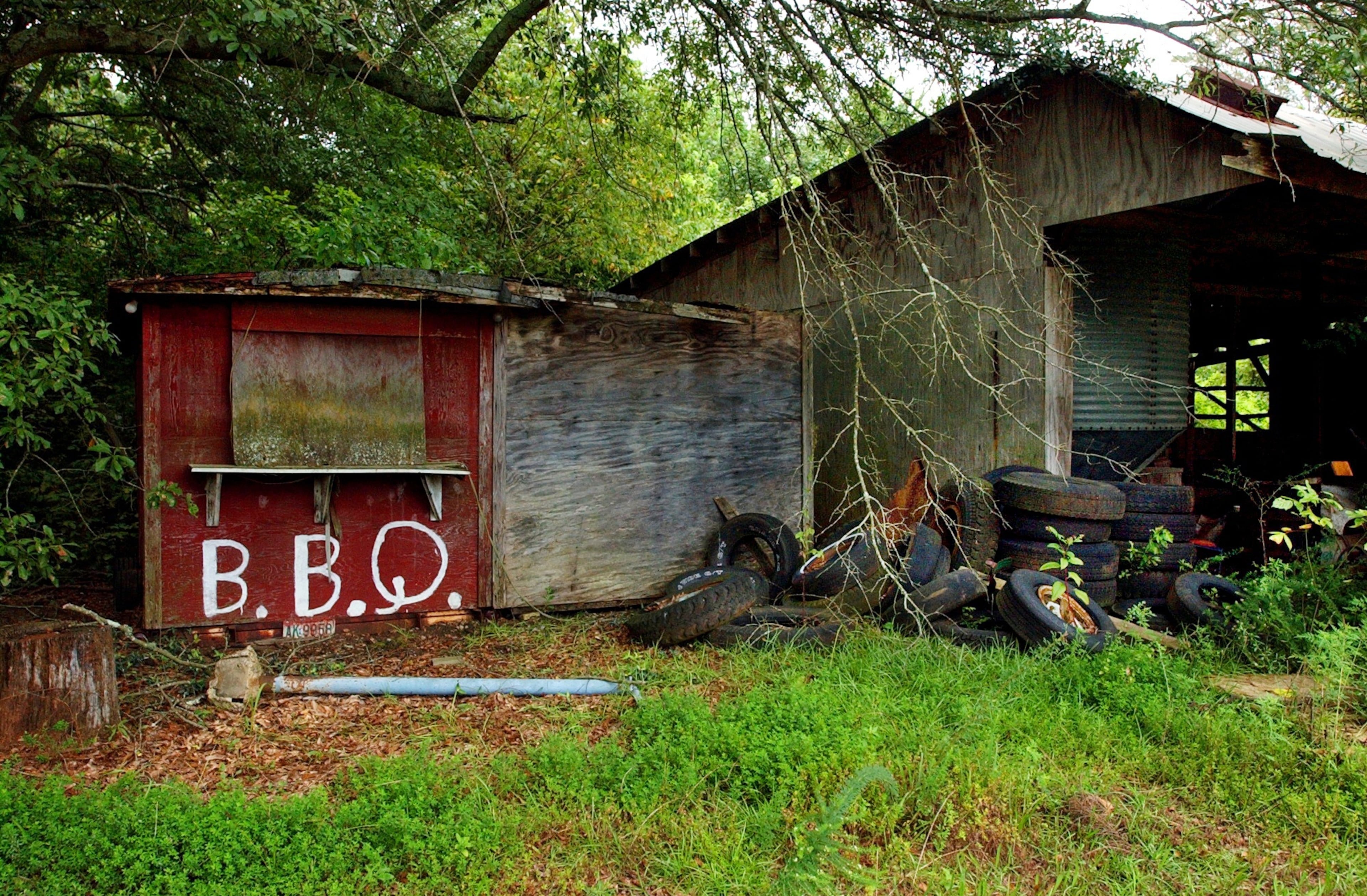 One more look at the town's past glory: In this 2003 photo, only remnants remain of a shack that once housed the most popular eatery in Rest Haven, Wade's Farmhouse BBQ. Although the owner, L.C. Wade, was known for his barbecue, his wife was the one that drew lake-goers (Lake Lanier) in for breakfast for some of her homemade biscuits. Often, breakfast was 'standing room only'. The location? Thunder Road, which was named by Mr. Wade. (CHARLOTTE B. TEAGLE / AJC file)