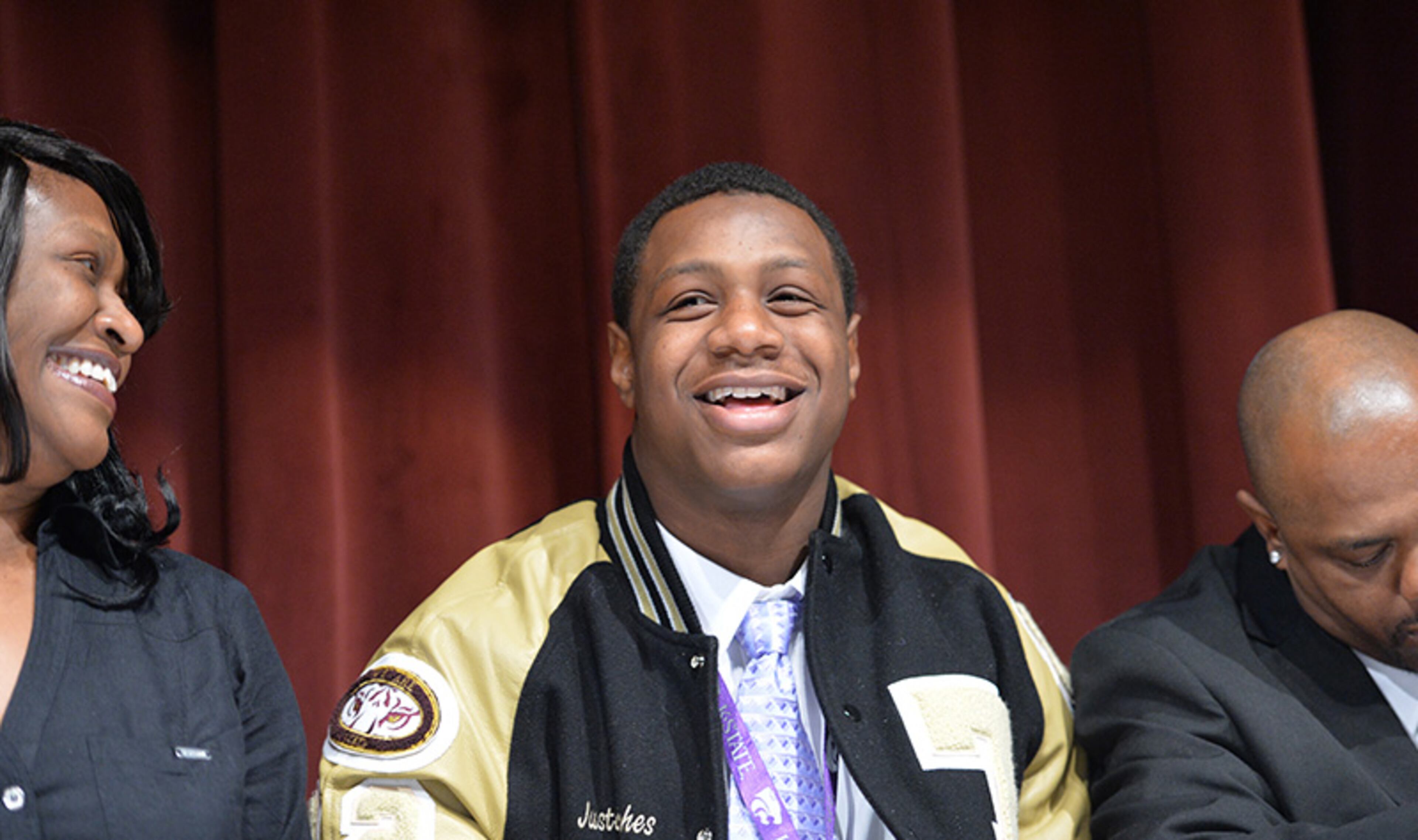 Justin Hughes smiles after he signed with Kansas State during signing day at Tucker High School.