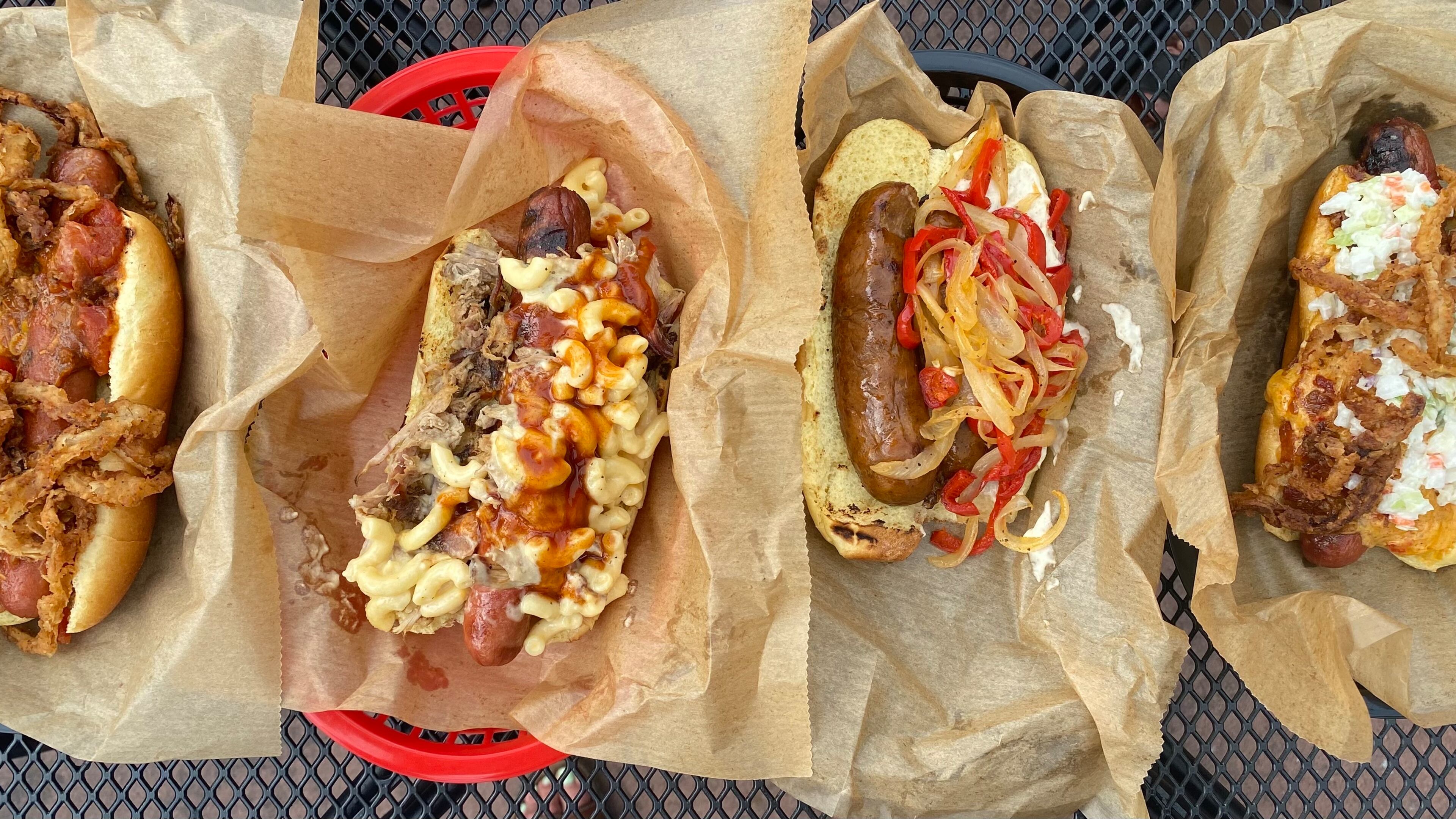 DBA is a barbecue mainstay, but it also offers quarter-pound beef frankfurters. Pictured from left are the stew dog, Mac Daddy, andouille dog and DBA dog. Ligaya Figueras/ligaya.figueras@ajc.com