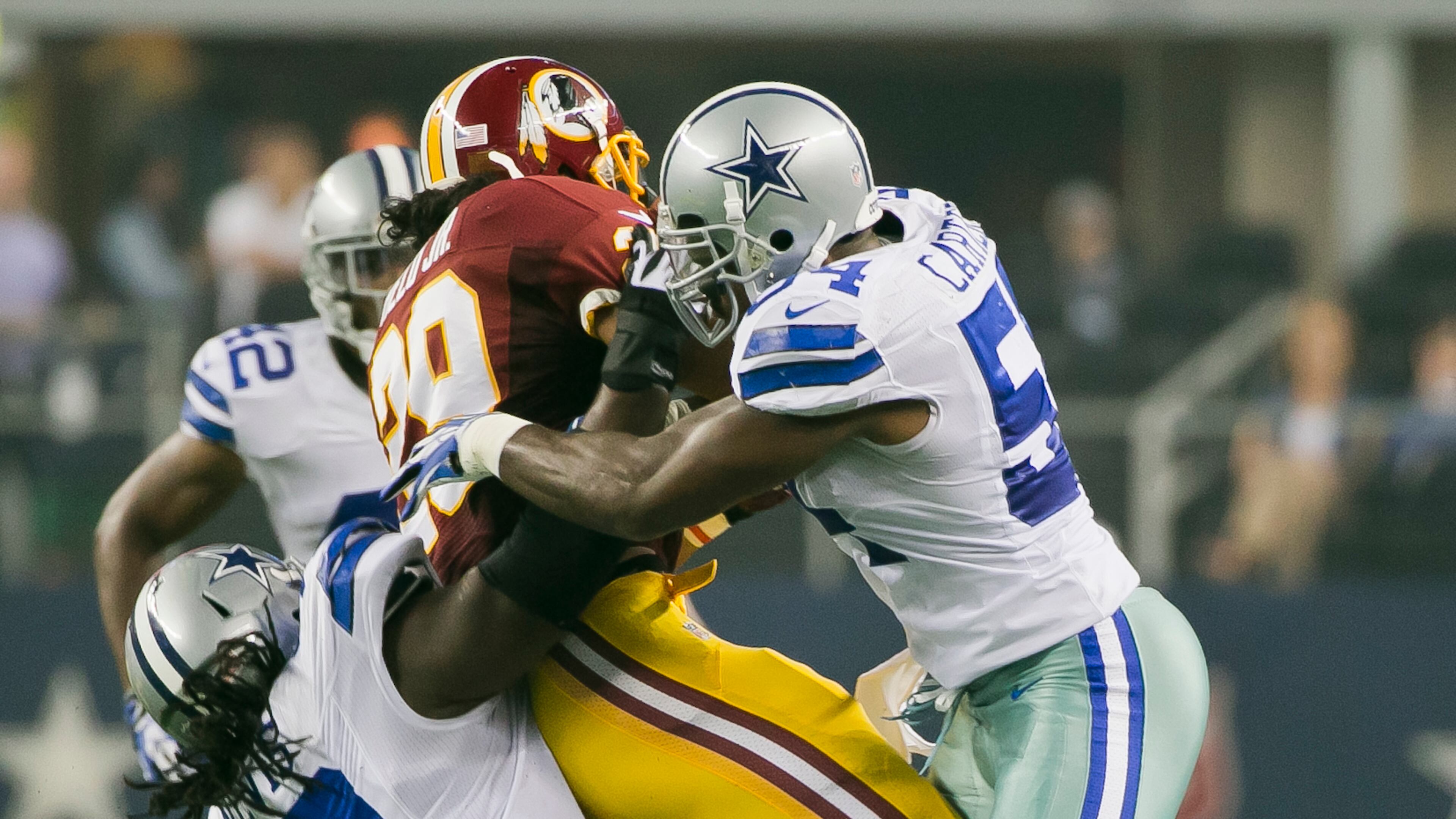 Dallas Cowboys (54) Bruce Carter and (70) Drake Nevis takes down Washington Redskins (29) Roy Helu Jr. during the first half of an NFL football game, in Arlington, Texas on Sunday, Oct. 13, 2013.