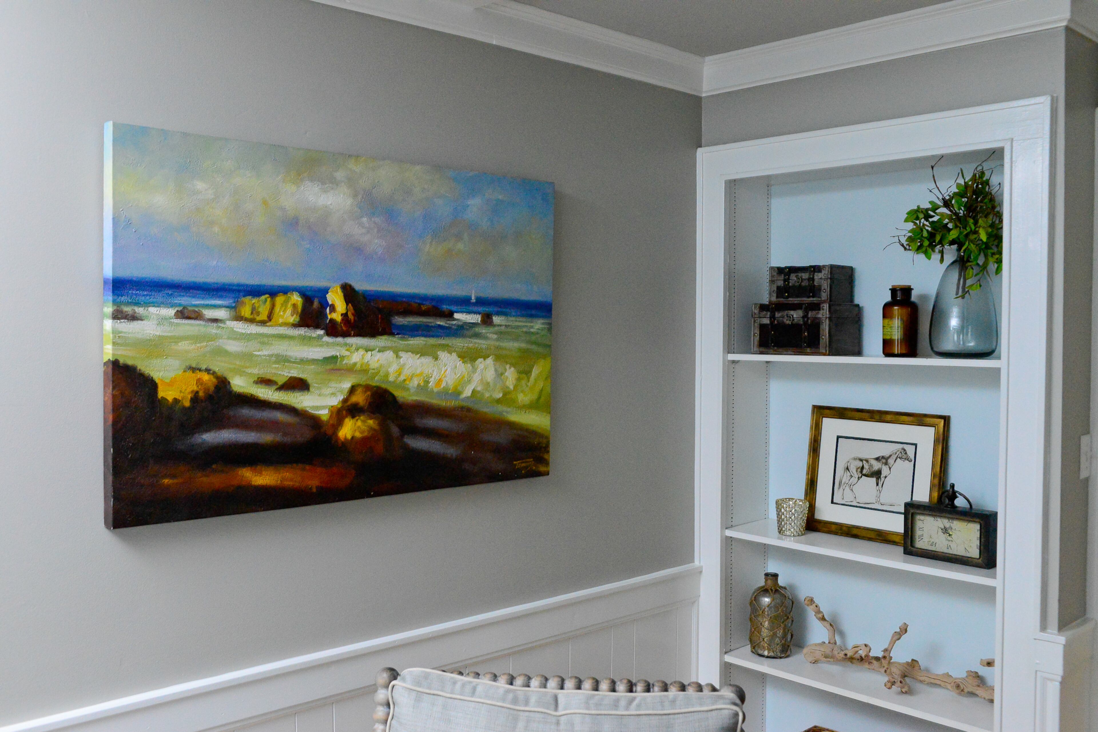 Homeowner Renee Morehouse loved the colors in this bold canvas painting from HomeGoods, which pops on walls painted Sherwin-Williams' Mindful Gray in the living room.