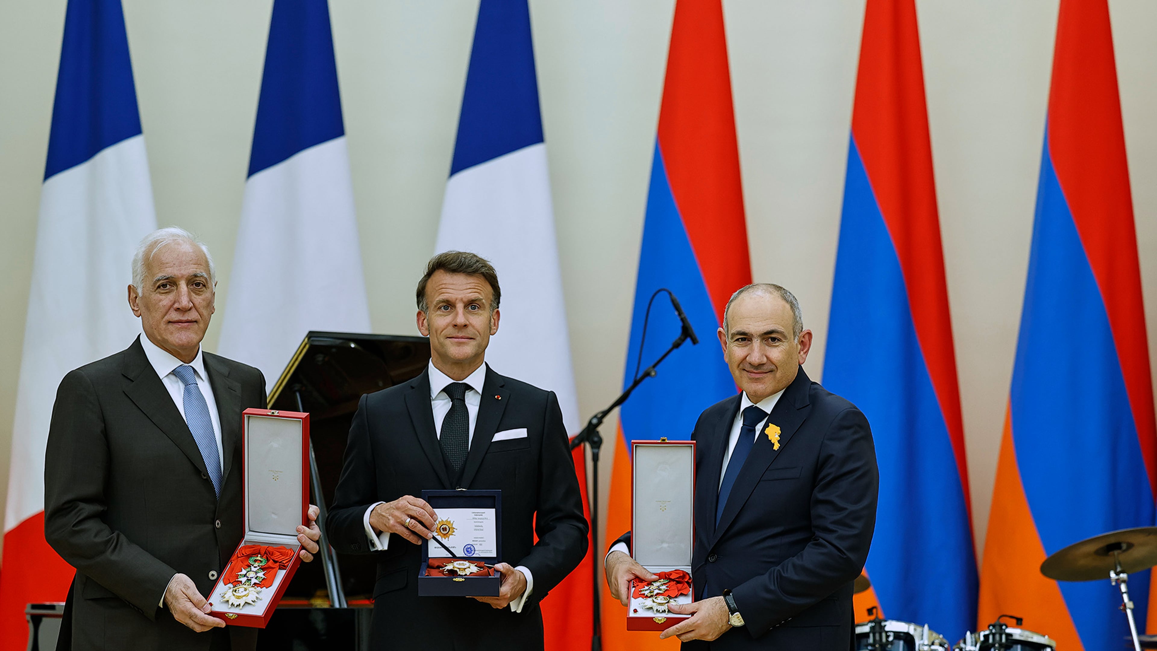 In this photo distributed by the Armenian Prime Minister Press Office, Armenian President Vahagn Khachaturyan, left, French President Emmanuel Macron, center, and Armenian Prime Minister Nikol Pashinyan hold awards following a state dinner after the European Political Community in Yerevan, Armenia, Monday, May 4, 2026. (Tigran Mehrabyan/Armenian Prime Minister Press Office via AP)