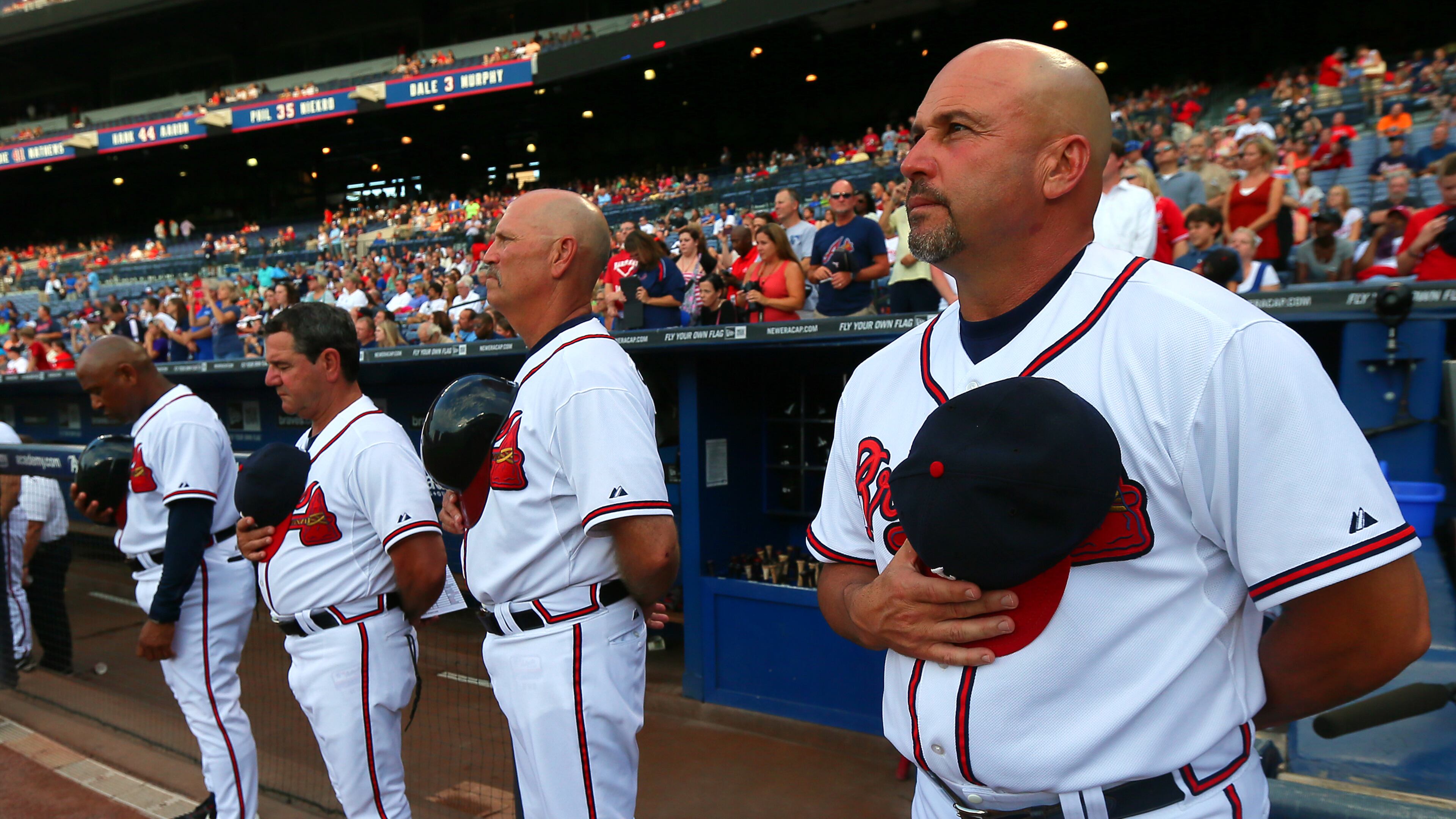 Atlanta Braves manager Fredi Gonzalez (from right to left), coaches Brian Snitker, Carlos Tosca, Terry Pendleton, players and fans observe a moment of silence for Ronald Lee Homer, 30, of Conyers, who fell to his death before the start of their game against the Phillies at Turner Field on Tuesday, August 13, 2013, in Atlanta. CURTIS COMPTON / CCOMPTON@AJC.COM