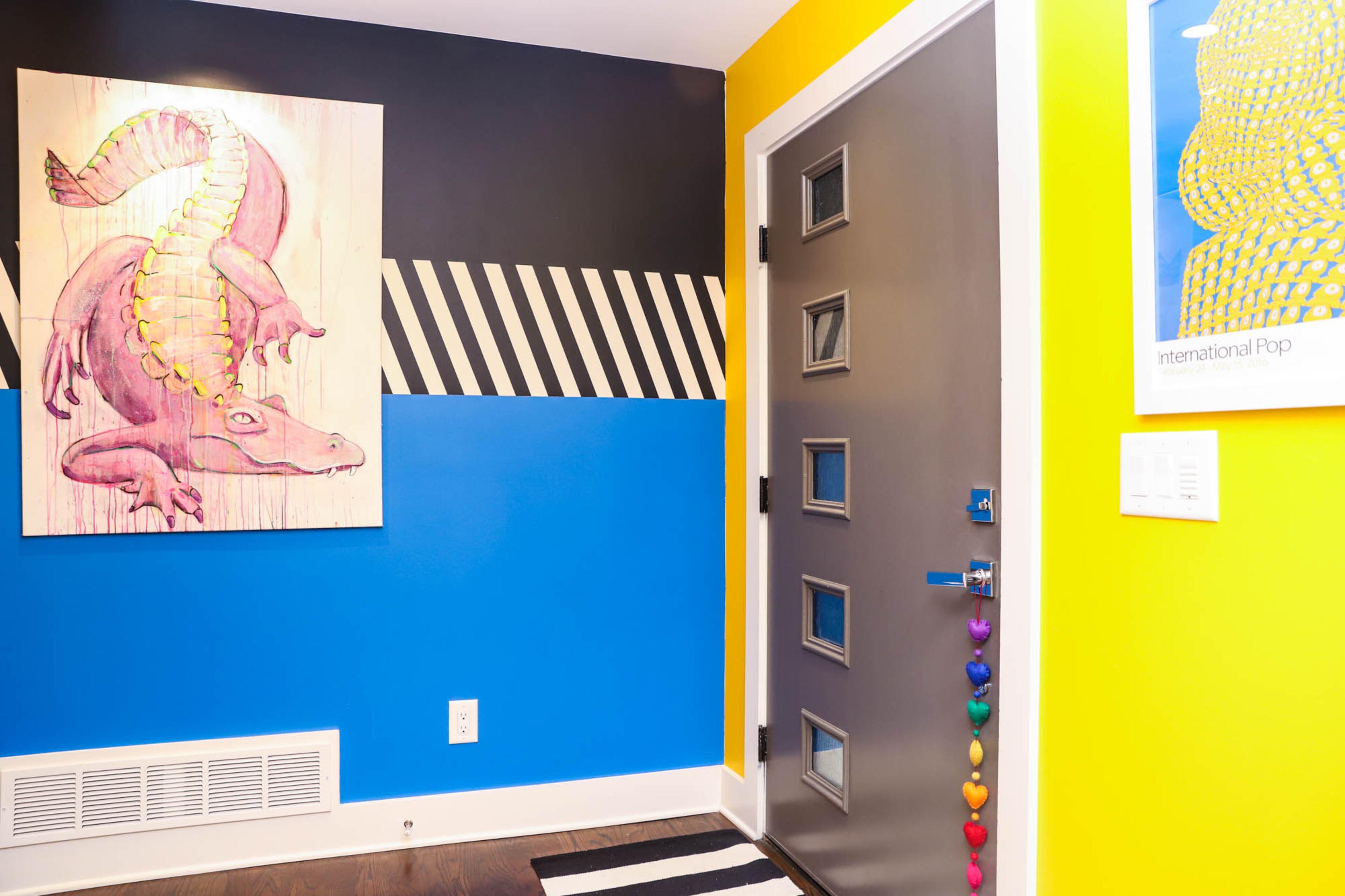 In the entryway of Paola and Jeff Roder’s home hangs a painting of a large pink alligator entitled “Gay Gator” by local artist Liz Haywood. Paola painted the entryway in primary colors and black and white patterns to fit into the Pop Art theme throughout the home. Text by Shannon Dominy. Photo by Reynolds Rogers.