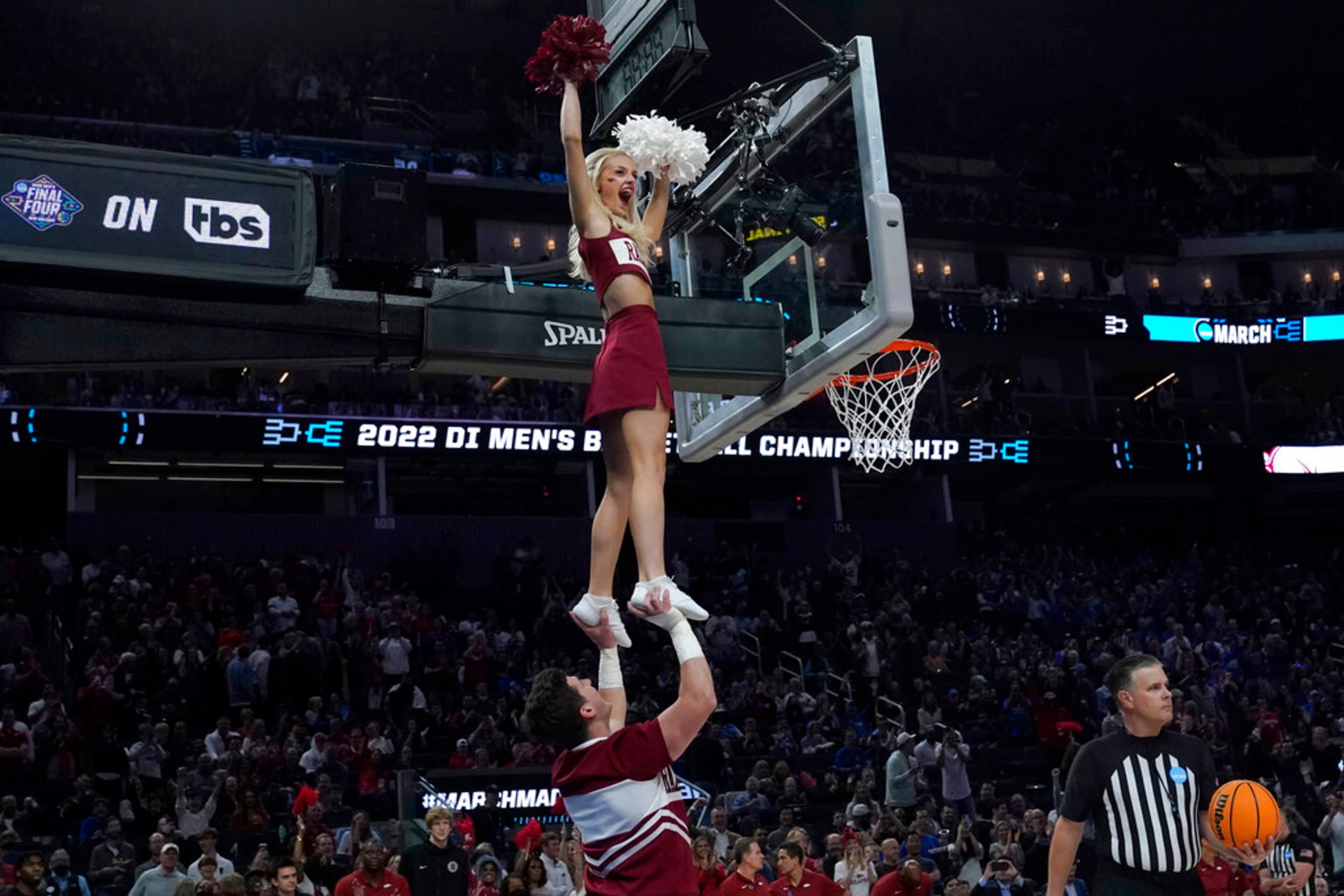 An Arkansas cheerleader reacts after retrieving a ball stuck on the top of the glass during the second half of a college basketball game between Duke and Arkansas in the Elite 8 round of the NCAA men's tournament in San Francisco, Saturday, March 26, 2022. (AP Photo/Marcio Jose Sanchez)