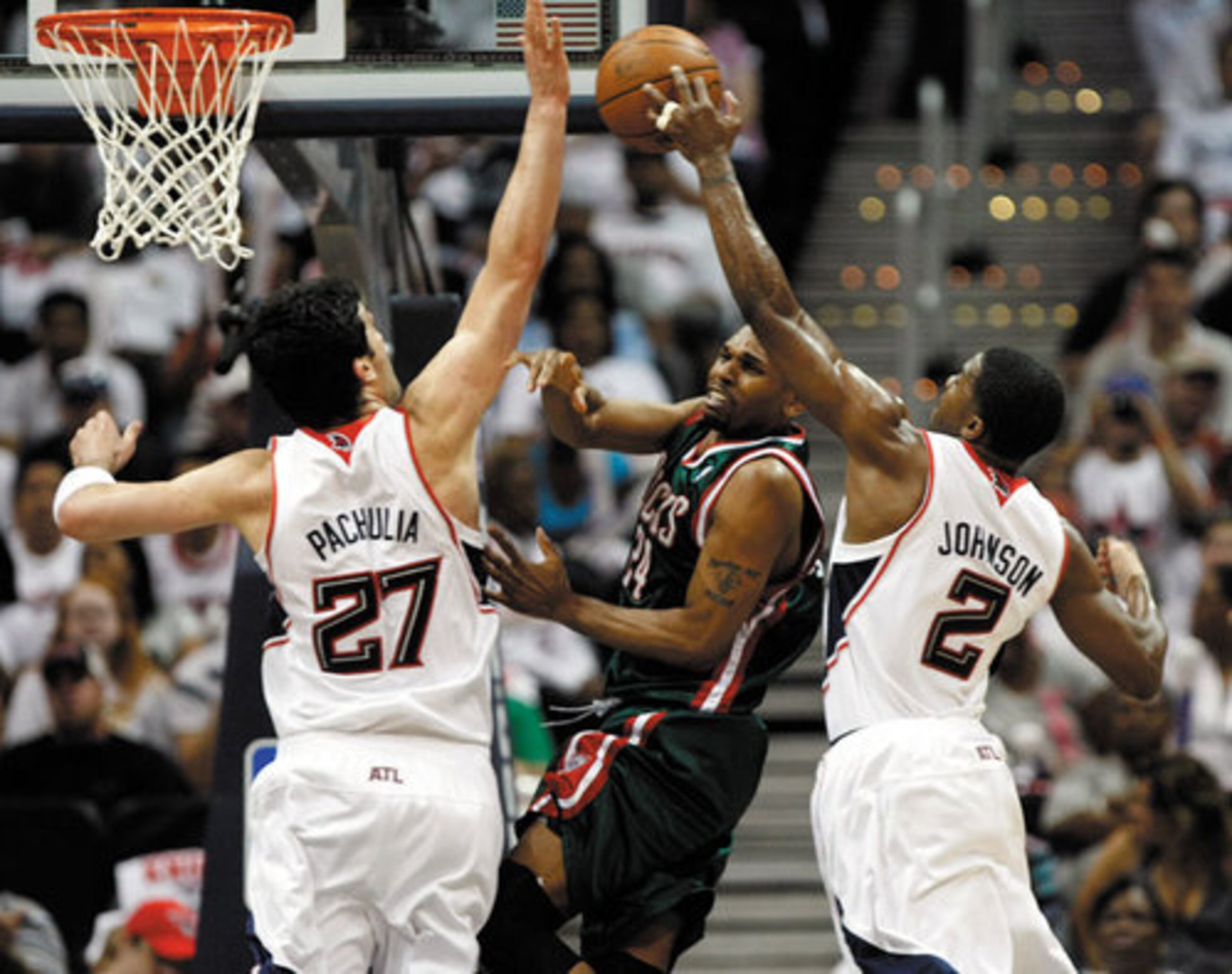 Atlanta Hawks guard Joe Johnson steals the ball from Milwaukee Bucks guard Jerry Stackhouse as Zaza Pachulia helps with the double team.