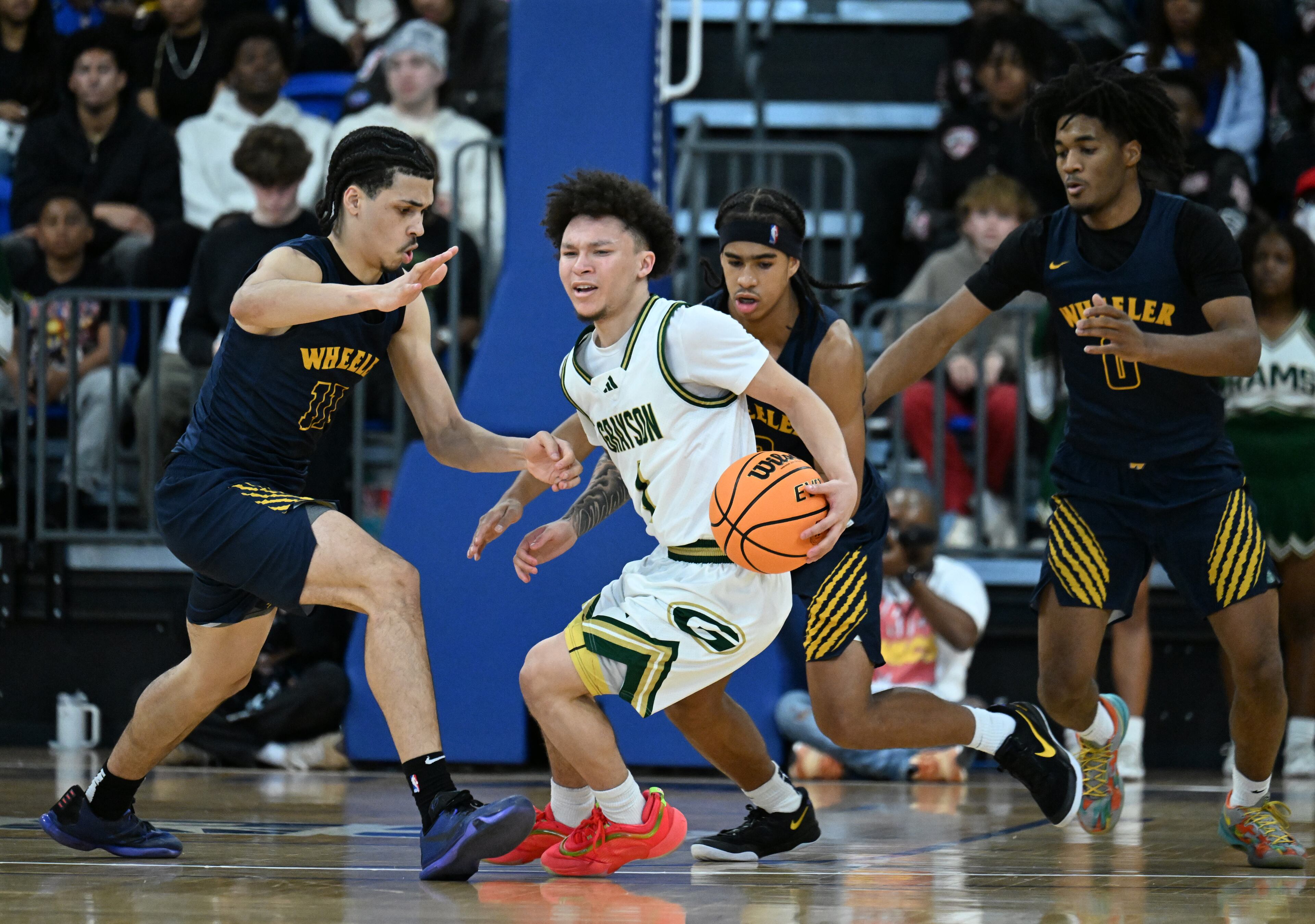 Grayson's Chris McLavish (center) gets pressure from Wheeler's Amare James (left) and Wheeler's Kevin Savage (right) during the second half of the GHSA Class 6A Boys State Basketball playoffs game at the Georgia State Convocation Center, Saturday, March 1, 2025, in Atlanta. Wheeler won 68-53 over Grayson. (Hyosub Shin / AJC)