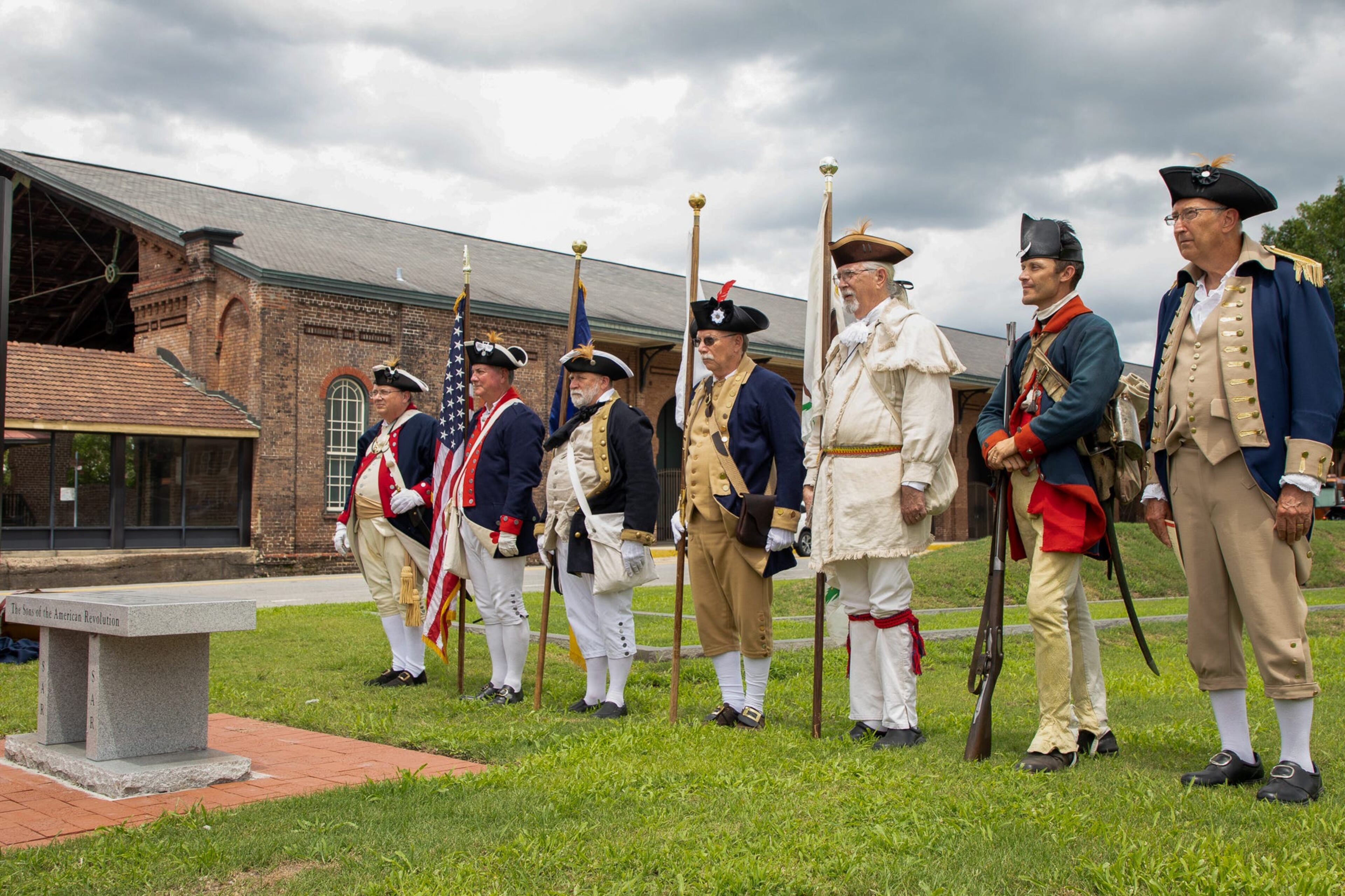The Georgia SAR Color Guard stands at attention to close out the granite bench dedication ceremony on July 14, 2022 at the Coastal Heritage Society Tricentennial Park.