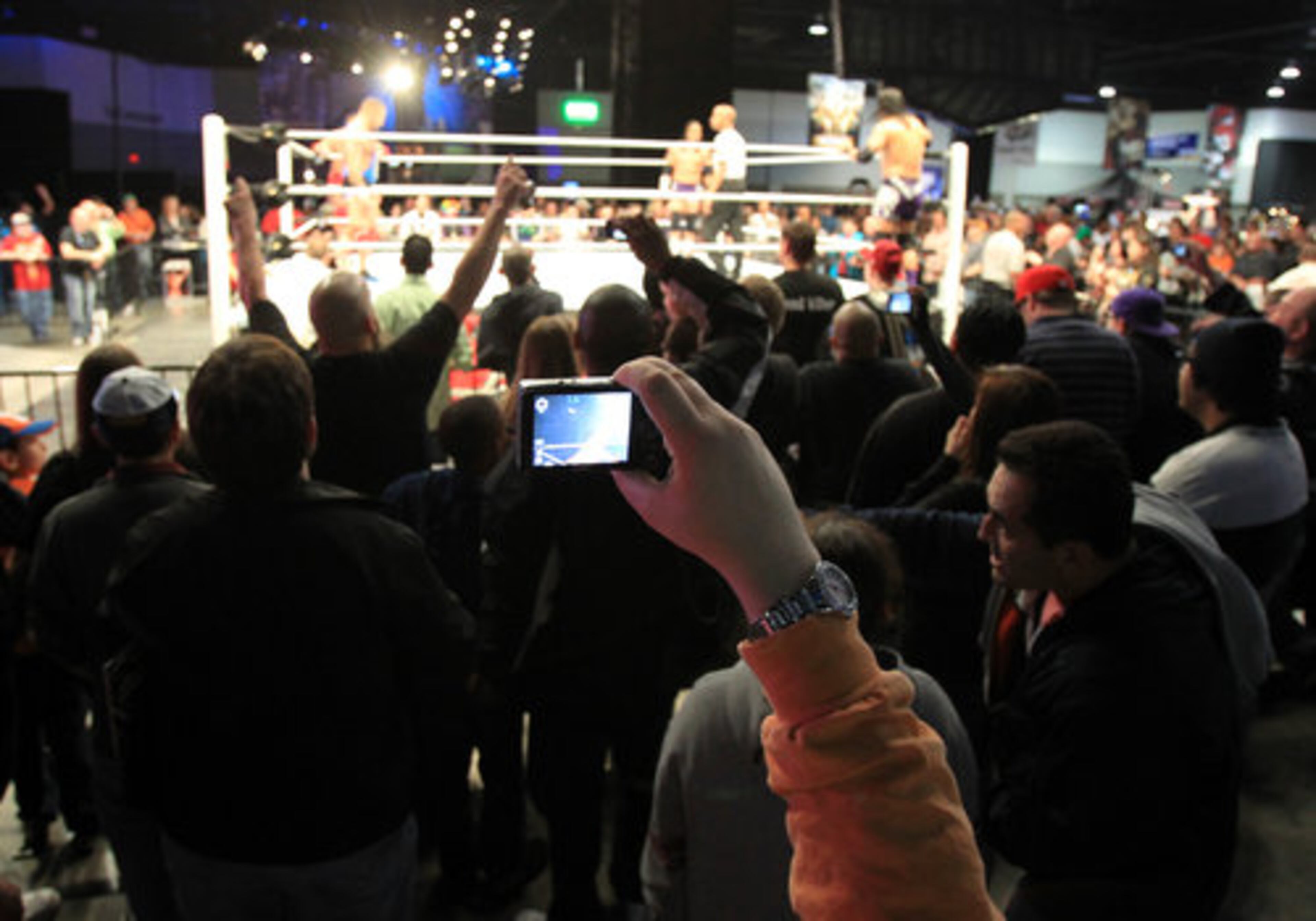 Wrestling fans crowd around The Main Event stage to watch a live match at WrestleMania Axxess, WWE's largest interactive fan experience, at the Georgia World Congress Center in Atlanta on Thursday, March 31, 2011.