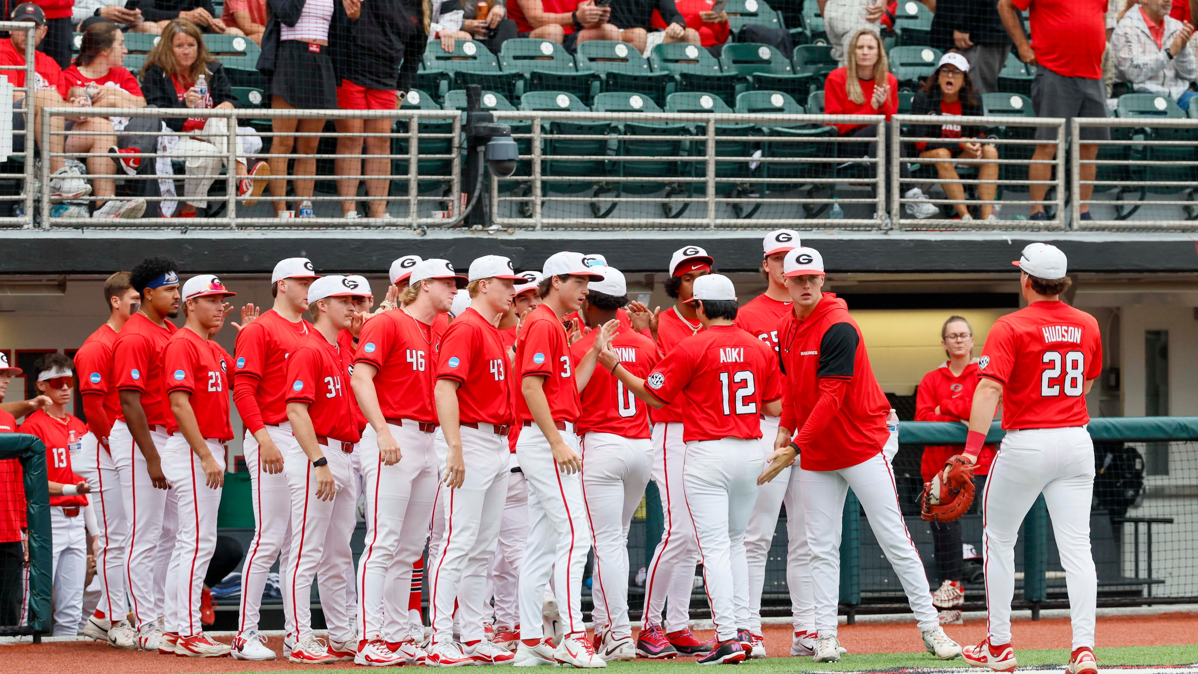 Georgia Bulldogs pitcher Caden Aoki receives high-fives after finishing the fifth inning of Sunday's NCAA Regional final game. (Miguel Martinez/AJC)
