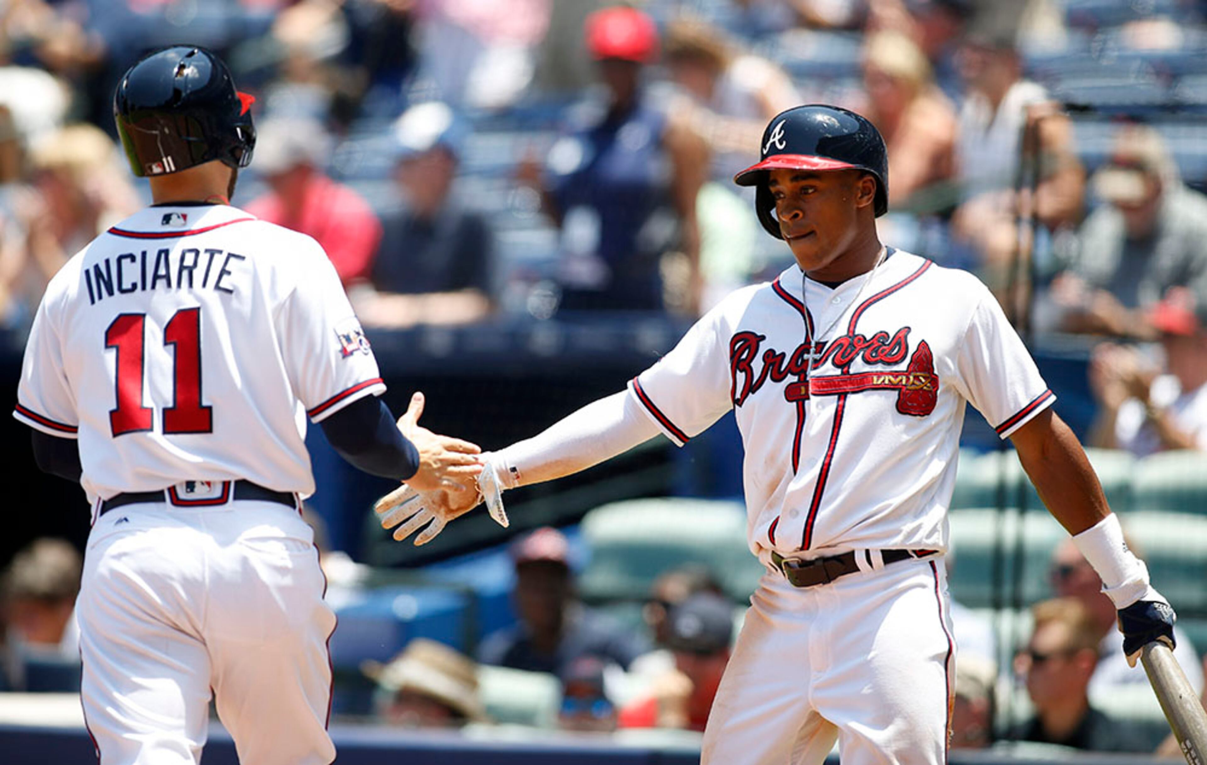 Braves outfielder Mallex Smith (right) congratulates Ender Inciarte after both score on a Nick Markakis double in the fifth inning gainst the Cincinnati Reds, Thursday, June 16, 2016, at Turner Field in Atlanta.