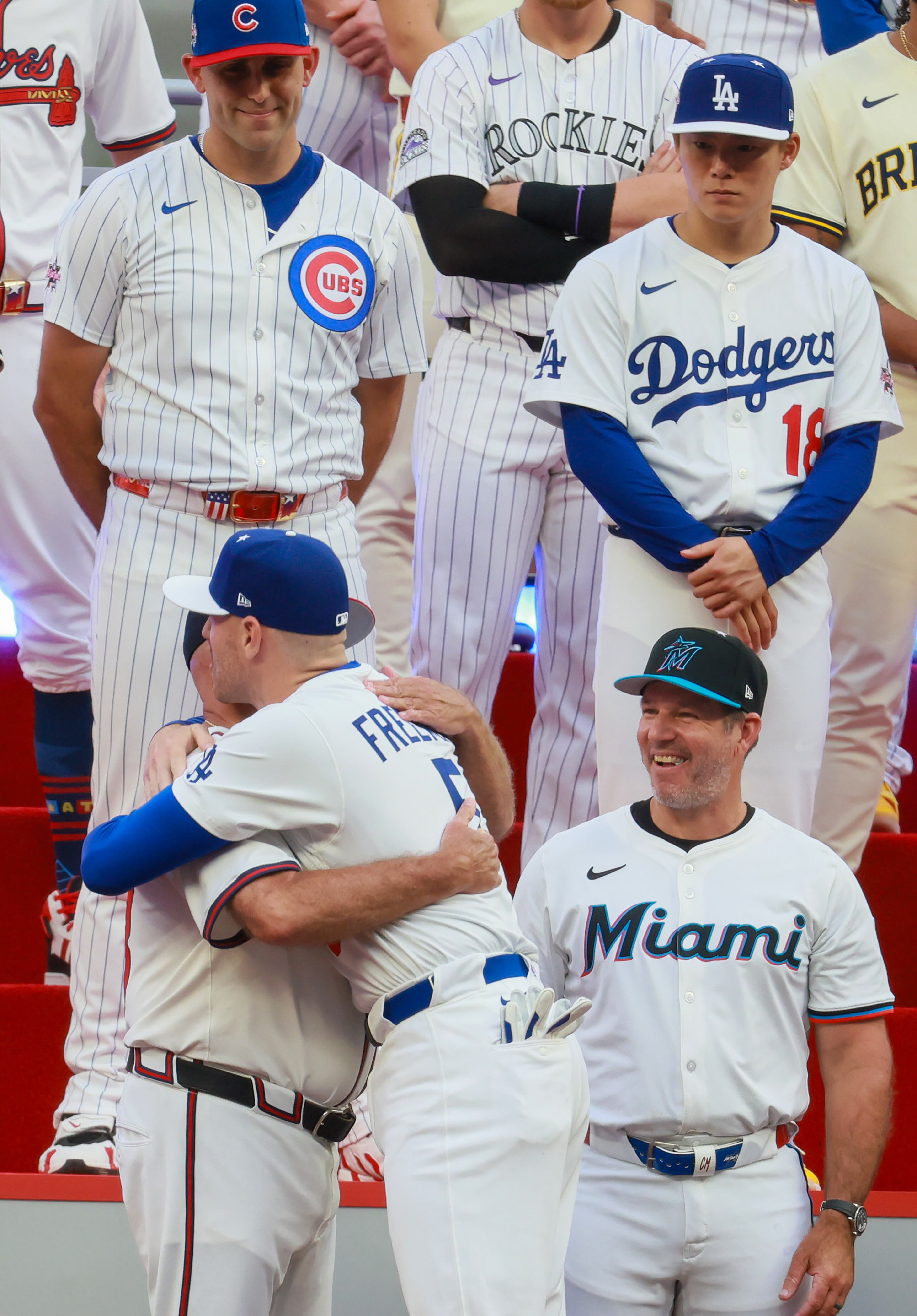 The National League's Freddie Freeman of the Los Angeles Dodgers hugs his former boss Atlanta Braves manager Brian Snitker during introductions for the MLB All-Star Game at Truist Park in Atlanta on Tuesday, July 15, 2025. (Jason Getz/AJC)