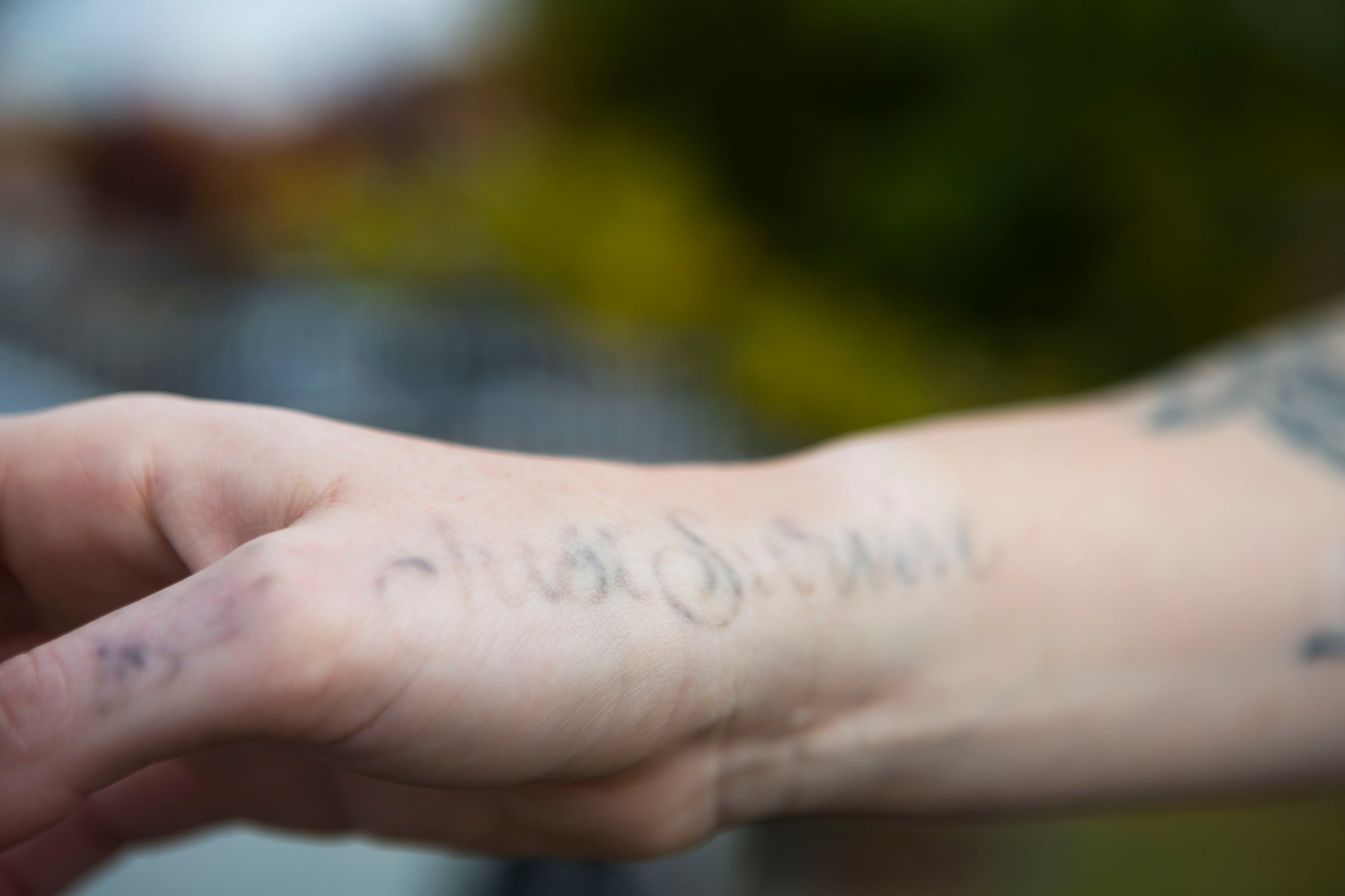 Melissa Walsh poses for a photo with one of her tattoos that is beginning to fade with laser treatments. The tattoo says "Just Survive." CHRISTINA MATACOTTA FOR THE ATLANTA JOURNAL-CONSTITUTION.